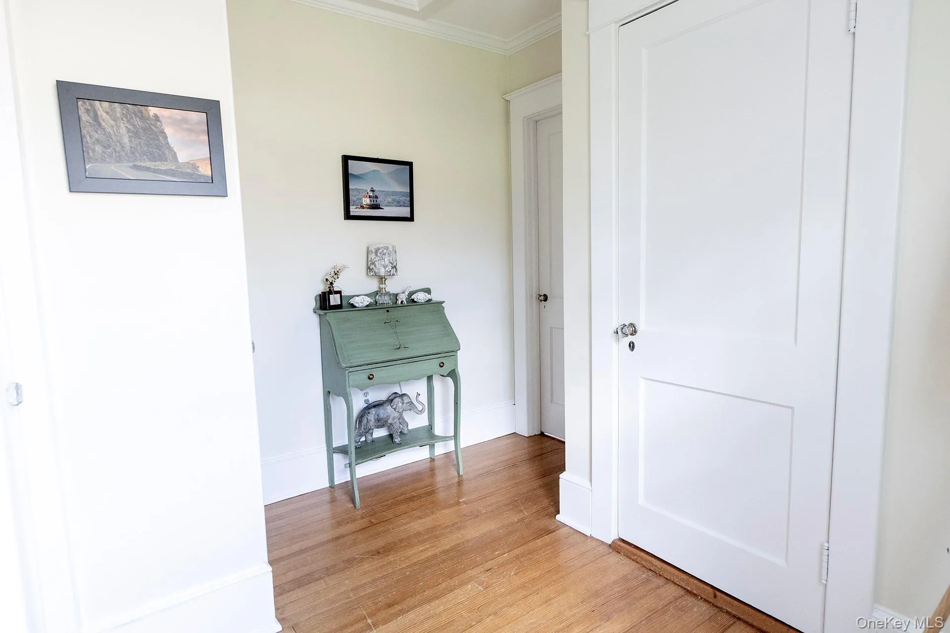 Hall featuring light wood-style floors and ornamental molding Hall featuring light wood-style floors and ornamental molding