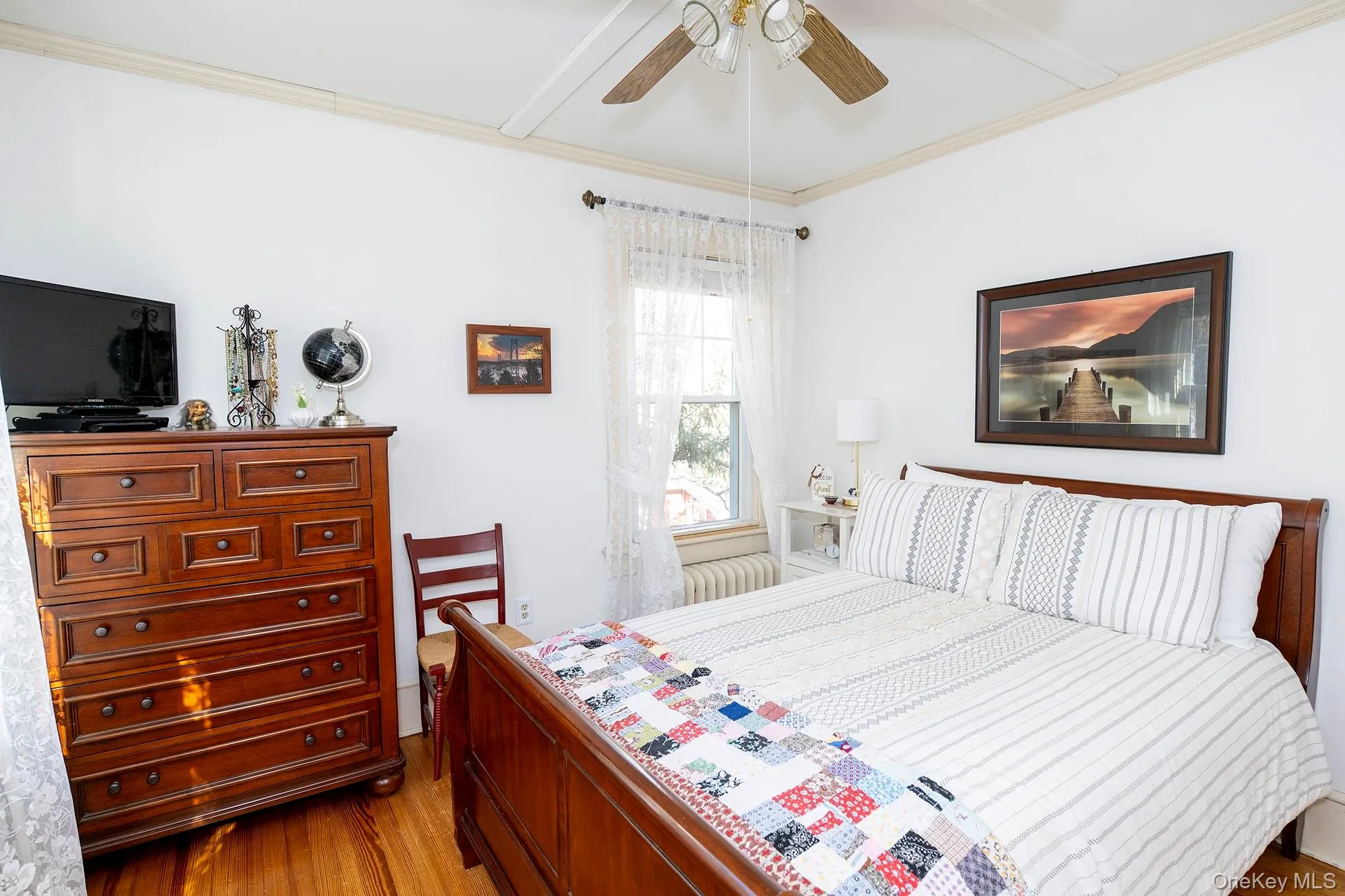 Bedroom with crown molding, wood finished floors, ceiling fan, and beam ceiling Bedroom with crown molding, wood finished floors, ceiling fan, and beam ceiling