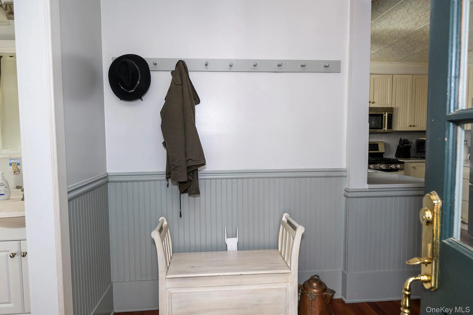 Mudroom featuring a wainscoted wall and dark wood-type flooring Mudroom featuring a wainscoted wall and dark wood-type flooring