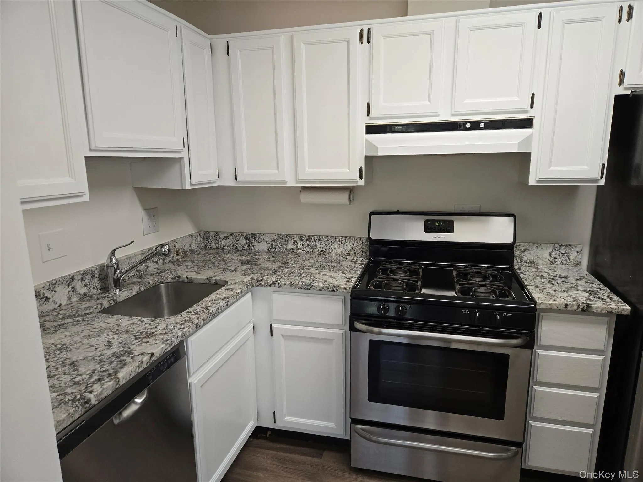Kitchen featuring white cabinetry, sink, and appliances with stainless steel finishes Kitchen featuring white cabinetry, sink, and appliances with stainless steel finishes