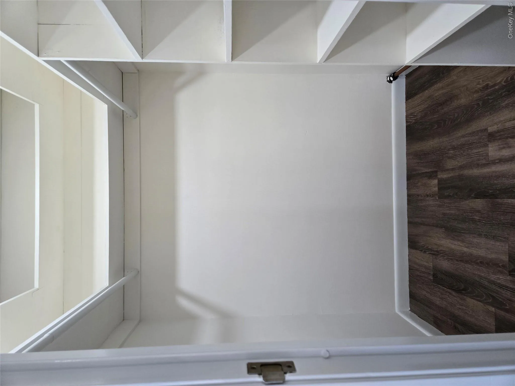 Spacious closet with dark hardwood / wood-style flooring Spacious closet with dark hardwood / wood-style flooring