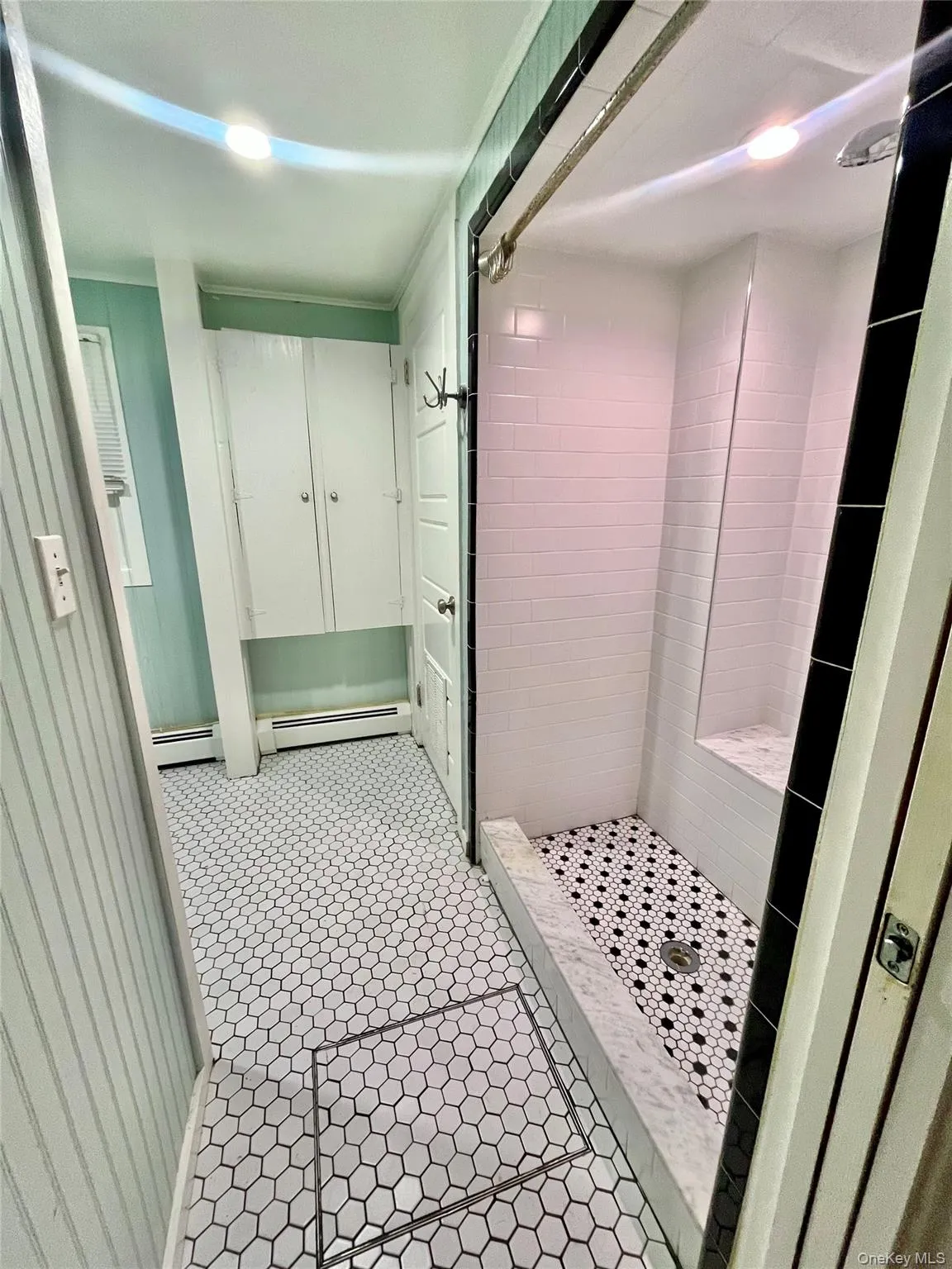 Bathroom featuring baseboard heating and a stall shower Bathroom featuring baseboard heating and a stall shower
