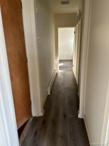 Hall featuring baseboards, visible vents, and a baseboard radiator Hall featuring baseboards, visible vents, and a baseboard radiator