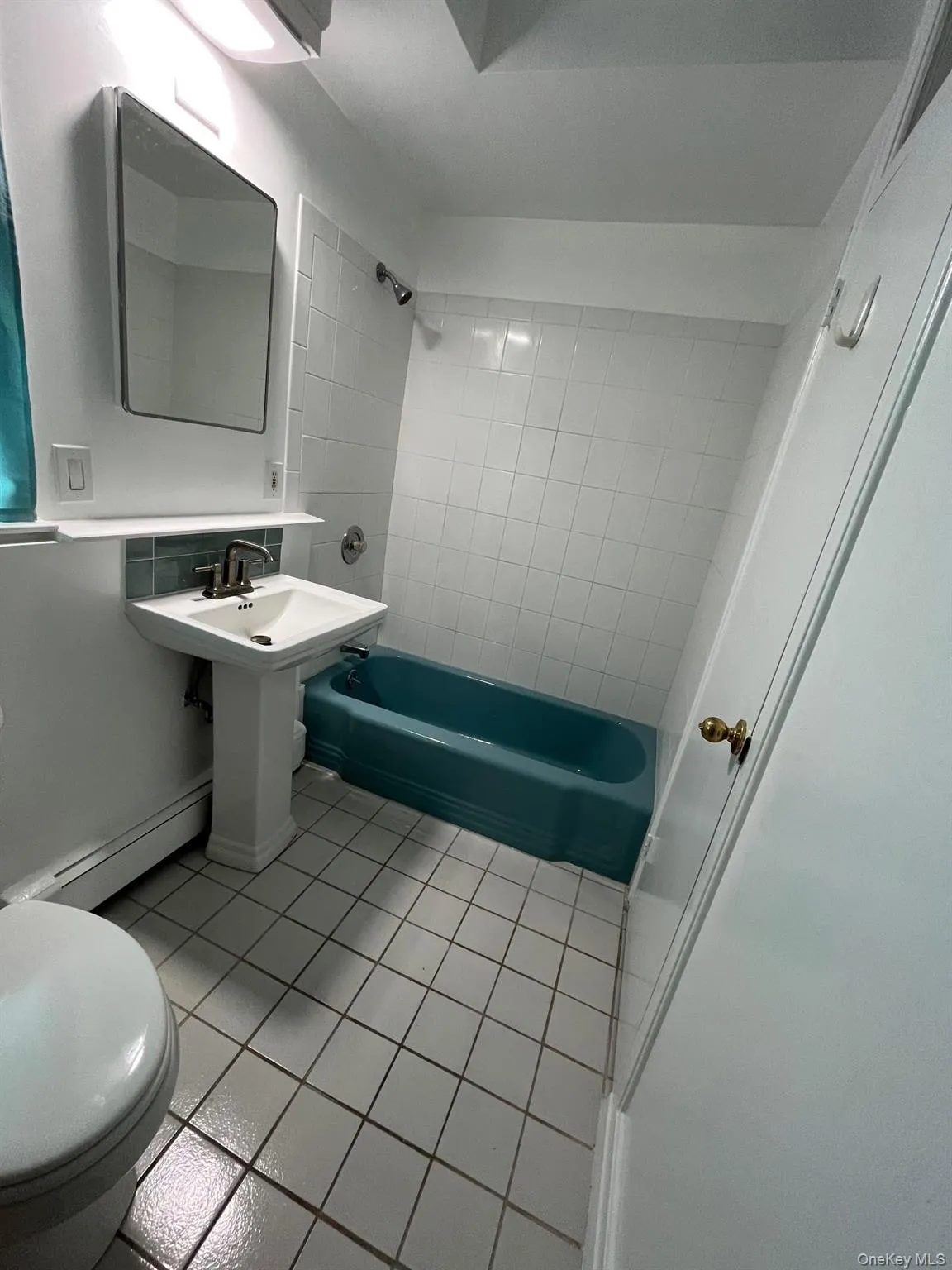 Bathroom with tile patterned floors, washtub / shower combination, a baseboard heating unit, and toilet Bathroom with tile patterned floors, washtub / shower combination, a baseboard heating unit, and toilet