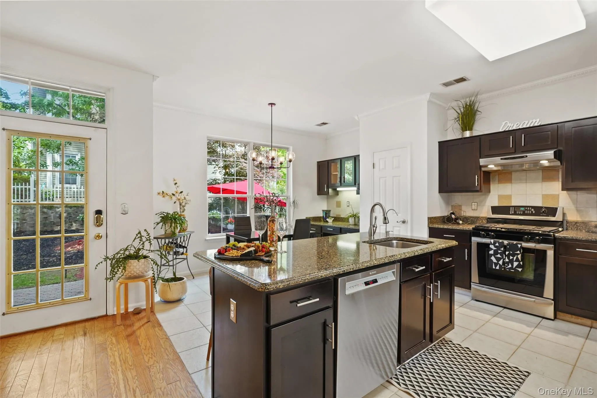 Kitchen featuring dark wood cabinetry, granite countertops, and stainless steel appliances Kitchen featuring dark wood cabinetry, granite countertops, and stainless steel appliances
