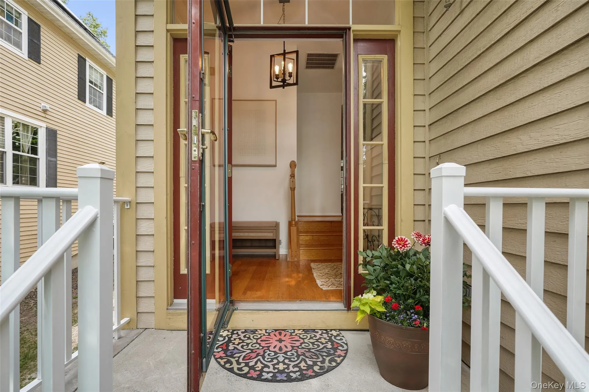 Inviting entryway featuring a storm door, an interior wood-finish door, and hardwood flooring Inviting entryway featuring a storm door, an interior wood-finish door, and hardwood flooring