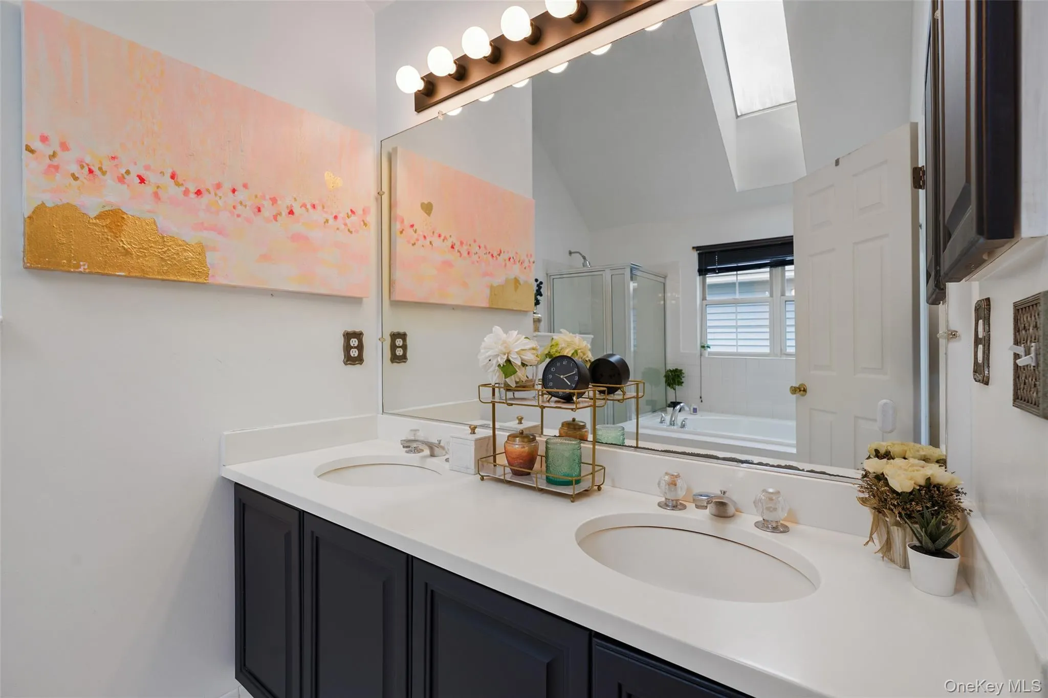 Dual vanity with dark cabinetry and light-toned countertops Dual vanity with dark cabinetry and light-toned countertops