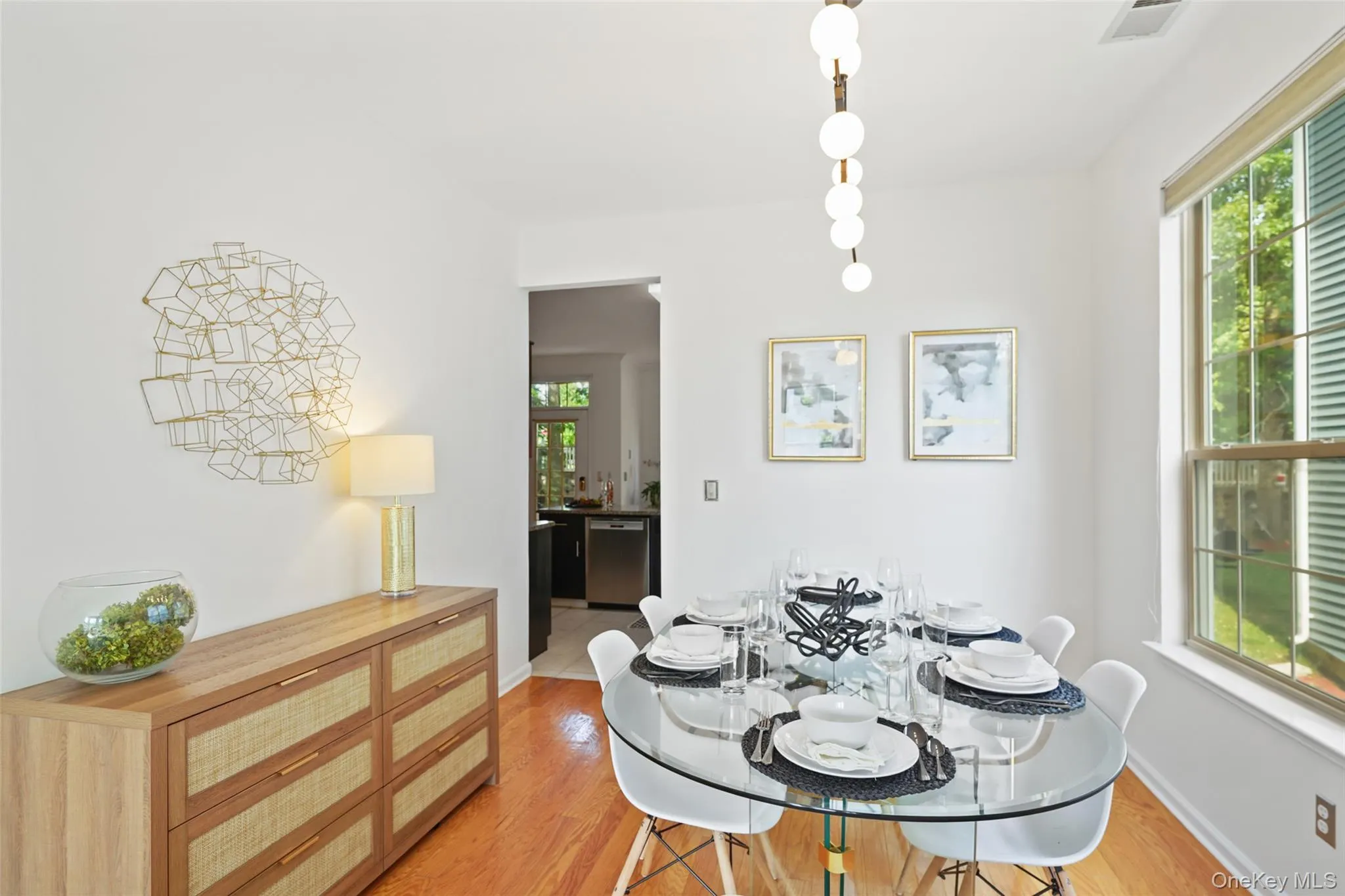Bright dining area featuring hardwood flooring, a multi-pane window with louvered blinds, and a contemporary chandelier Bright dining area featuring hardwood flooring, a multi-pane window with louvered blinds, and a contemporary chandelier