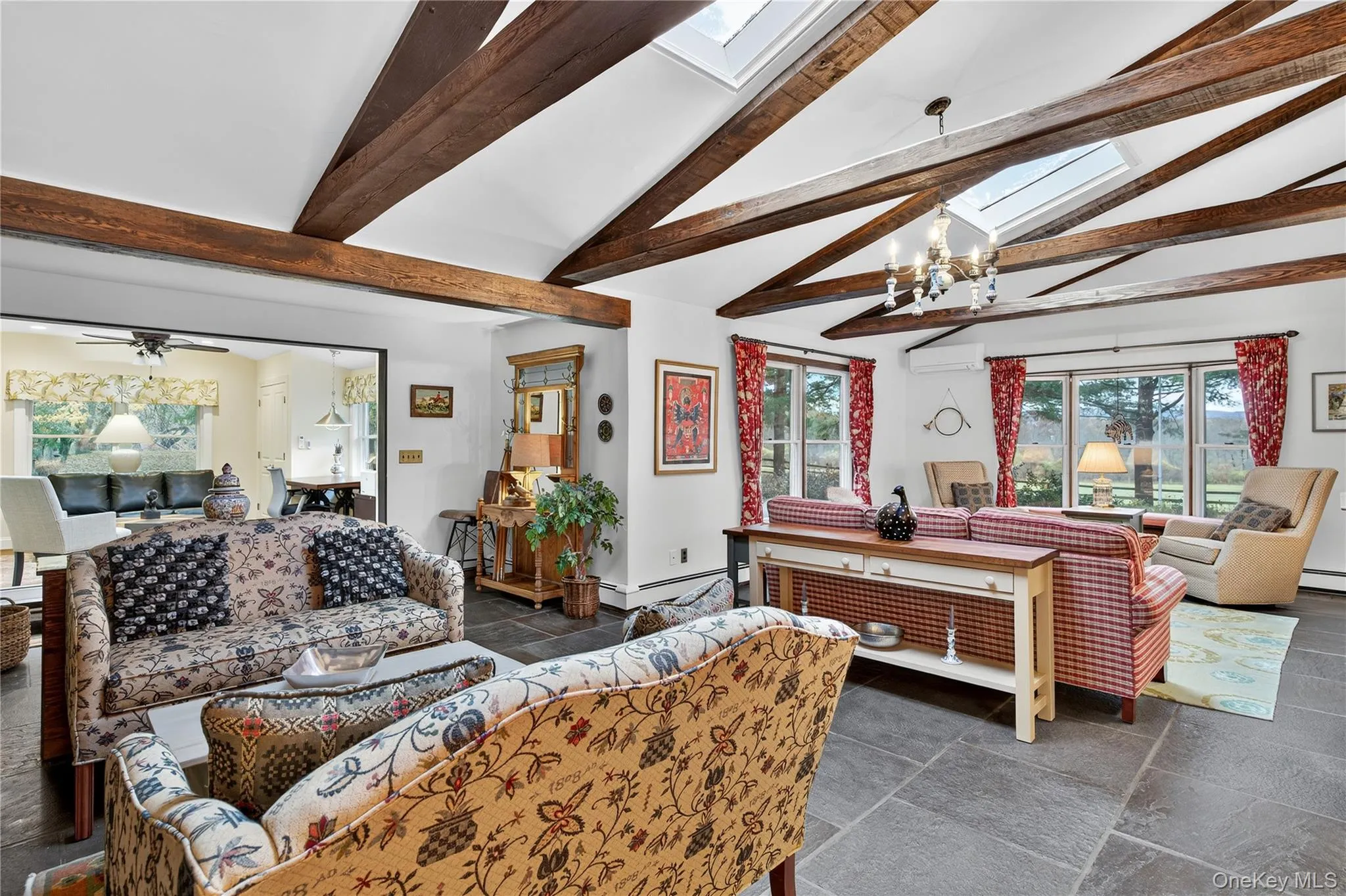 Great room with vaulted ceiling, exposed beams, skylights and stone flooring. Great room with vaulted ceiling, exposed beams, skylights and stone flooring.