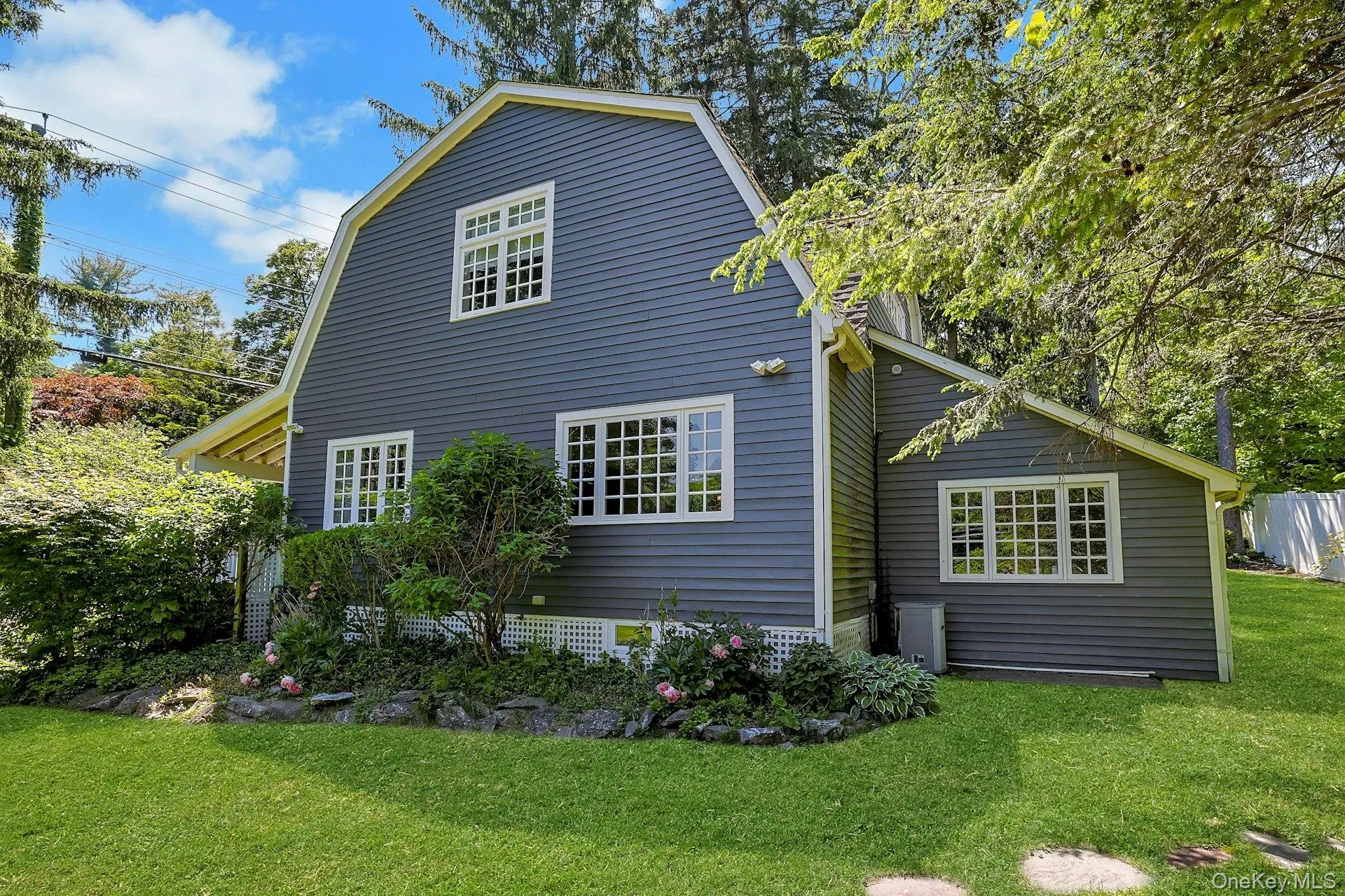 A beautifully landscaped side view of the home highlights the property’s natural charm, with lush greenery and thoughtfully designed grounds. A beautifully landscaped side view of the home highlights the property’s natural charm, with lush greenery and thoughtfully designed grounds.