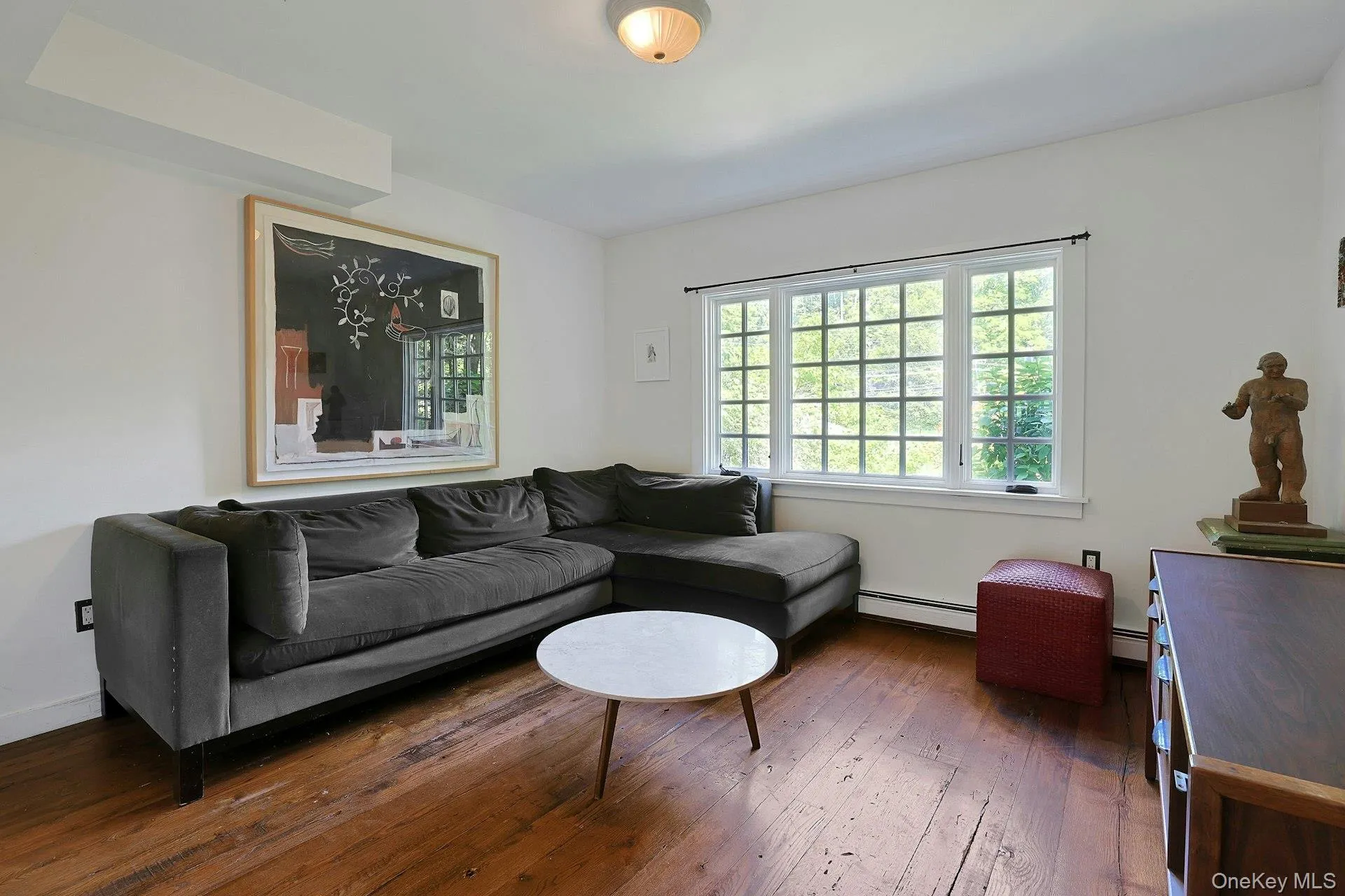 Sunlight highlights the rich hardwood floors in this spacious family room, creating a bright and welcoming setting Sunlight highlights the rich hardwood floors in this spacious family room, creating a bright and welcoming setting