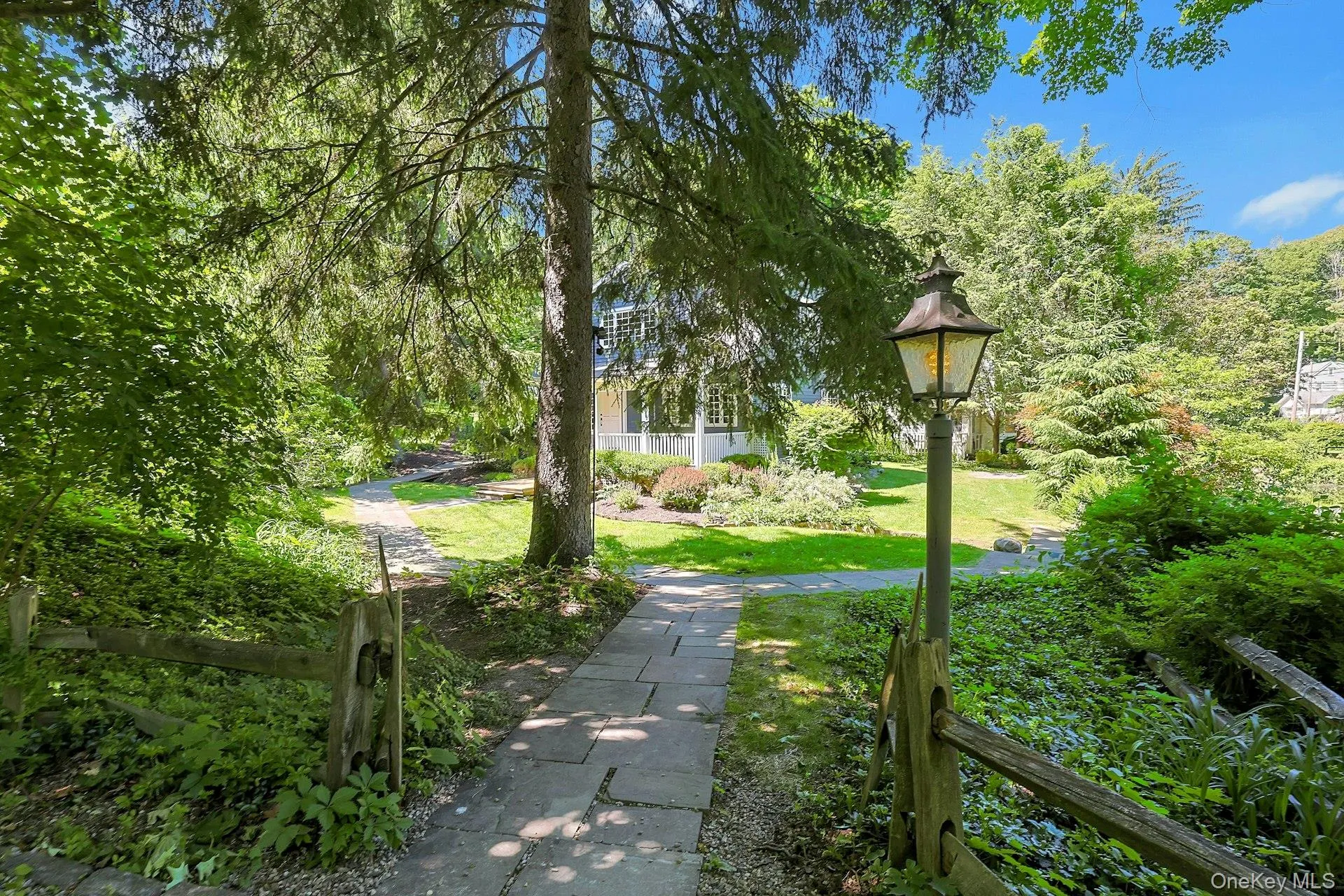 A charming walkway leads to the front of the home, surrounded by the beauty of the property’s landscaped grounds. A charming walkway leads to the front of the home, surrounded by the beauty of the property’s landscaped grounds.