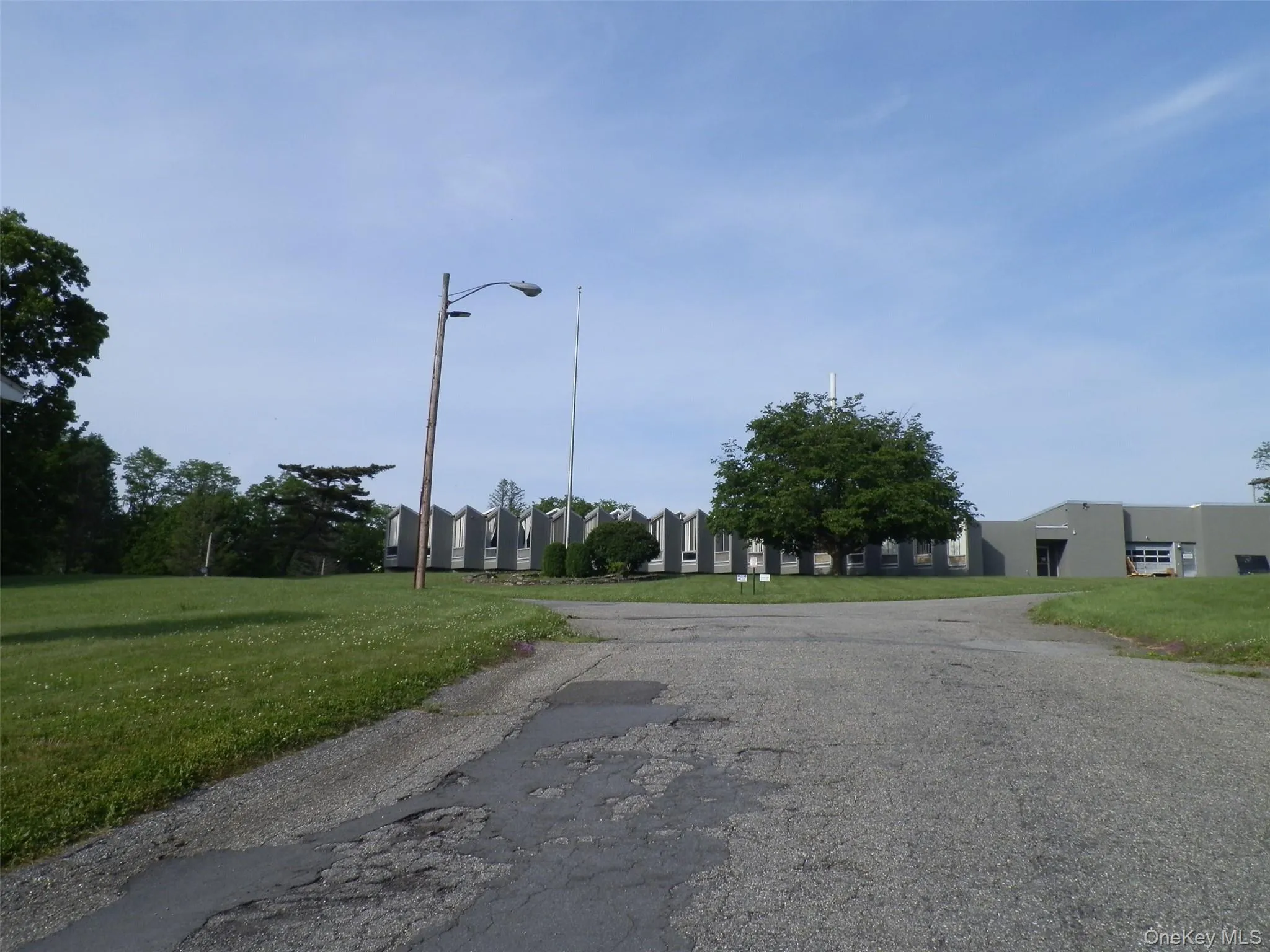 Driveway to property. Stay left behind office building. Driveway to property. Stay left behind office building.