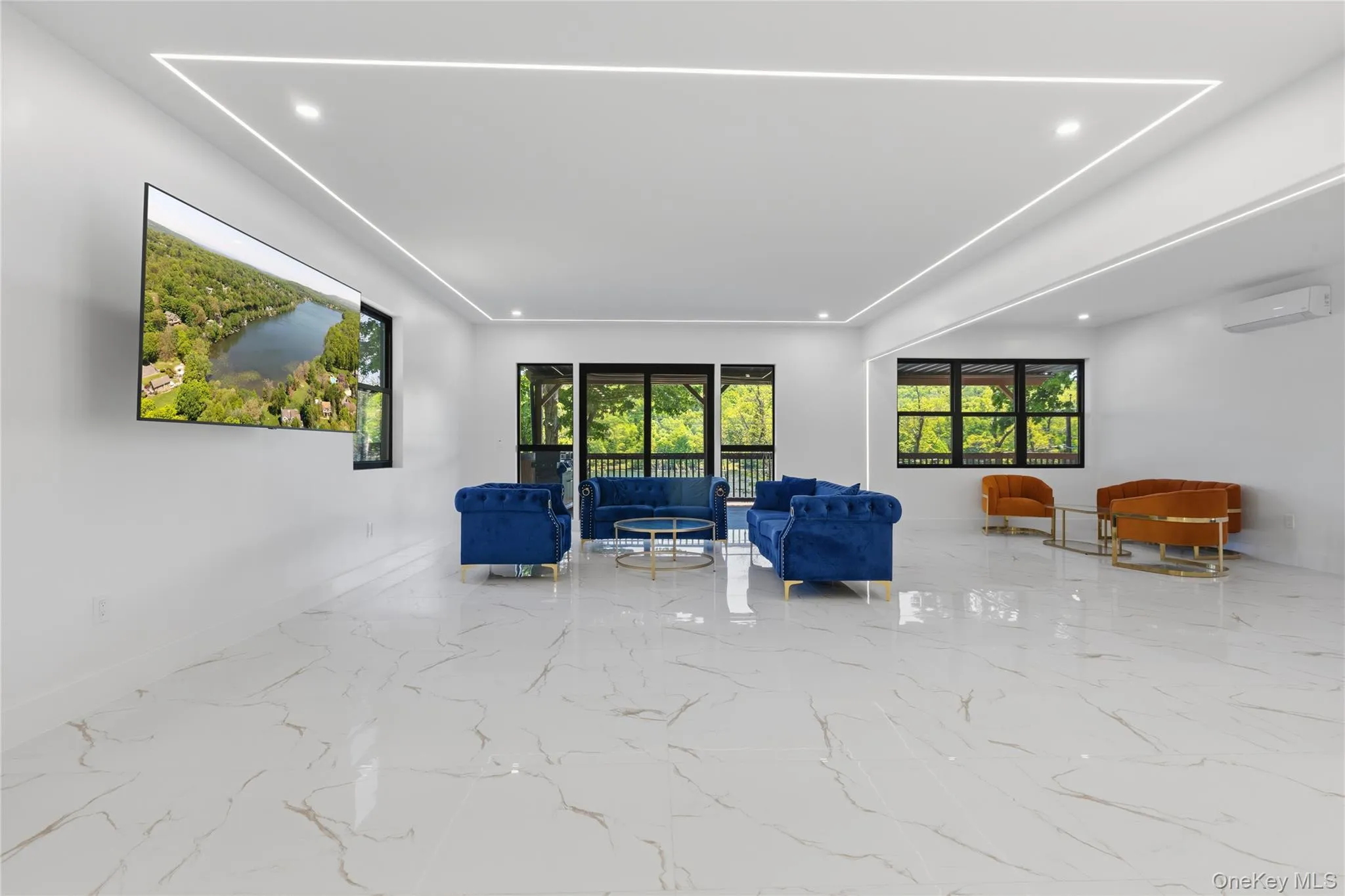 Spacious room featuring large format tile flooring, recessed lighting, and expansive windows Spacious room featuring large format tile flooring, recessed lighting, and expansive windows