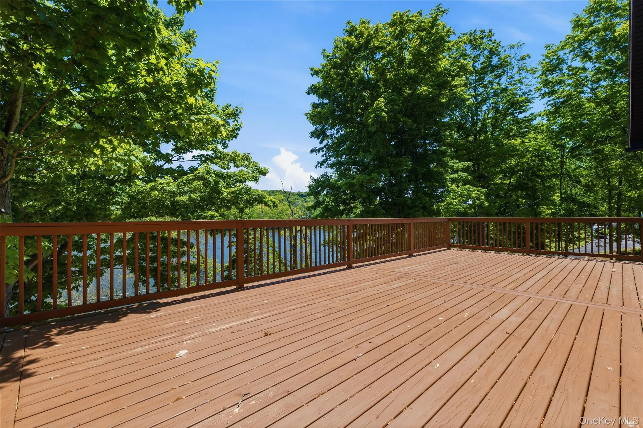 Spacious outdoor deck with wood-finish flooring and full perimeter railing Spacious outdoor deck with wood-finish flooring and full perimeter railing