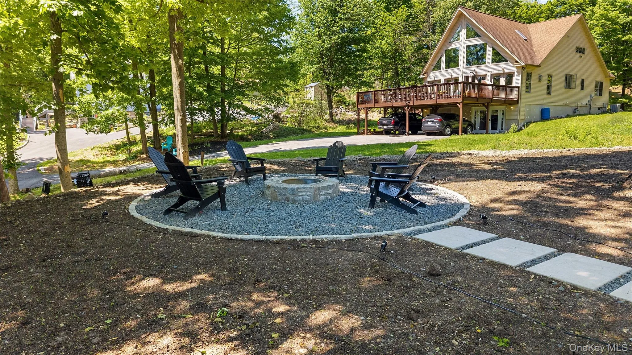 Outdoor fire pit with a gravel surround and concrete paver pathway Outdoor fire pit with a gravel surround and concrete paver pathway
