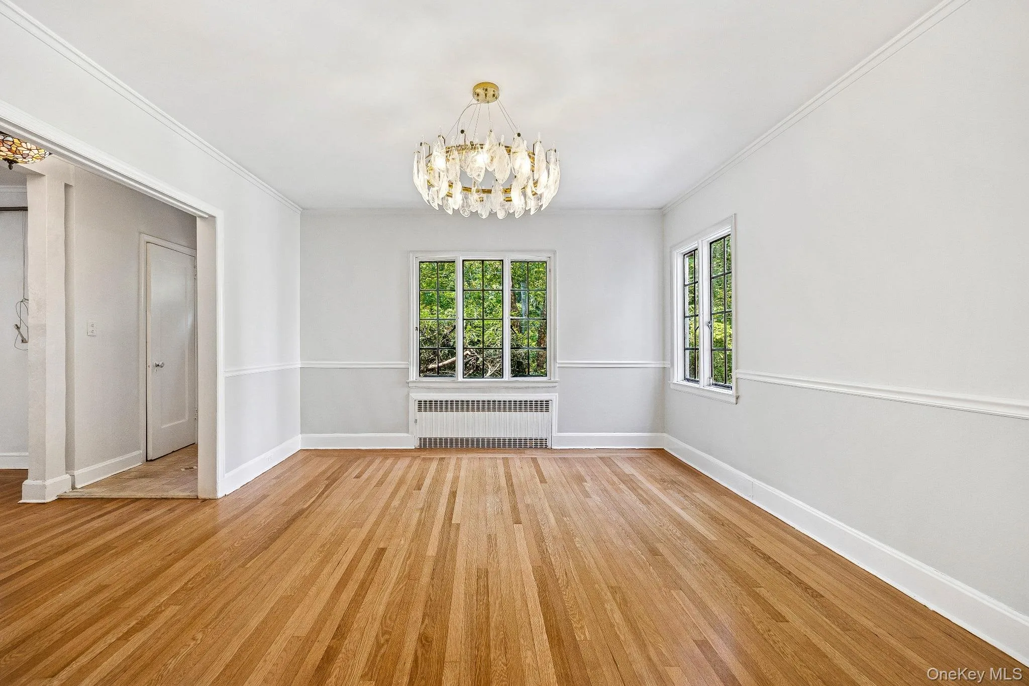Dinning room featuring light wood-style flooring, a chandelier, and ornamental molding Dinning room featuring light wood-style flooring, a chandelier, and ornamental molding