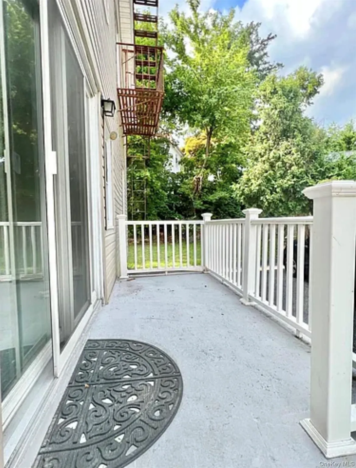 Private balcony featuring concrete flooring and white balusters Private balcony featuring concrete flooring and white balusters