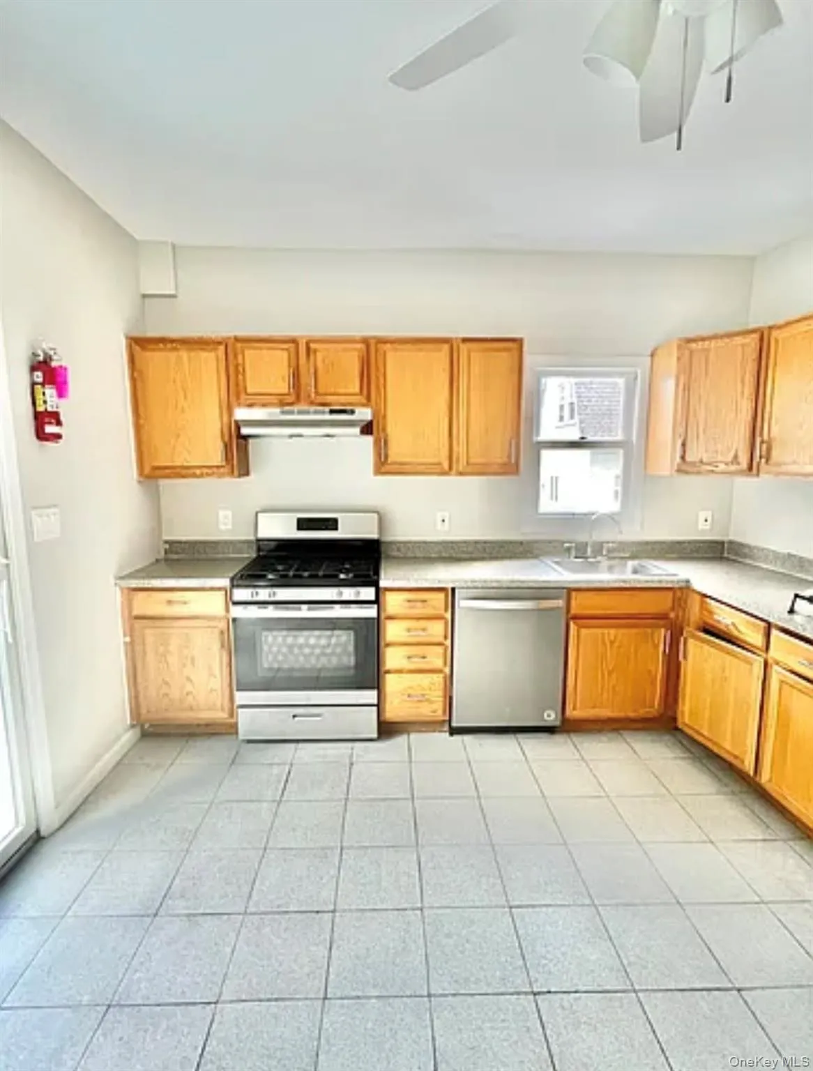 Kitchen featuring wood cabinetry, stainless steel range, stainless steel dishwasher, and a ceiling fan Kitchen featuring wood cabinetry, stainless steel range, stainless steel dishwasher, and a ceiling fan