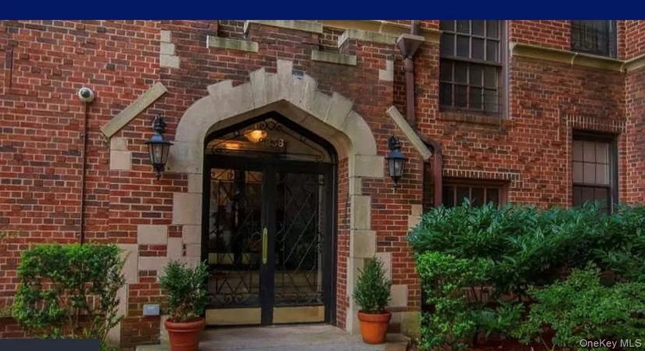 Brick exterior featuring a stone arched entryway with decorative metal doors Brick exterior featuring a stone arched entryway with decorative metal doors