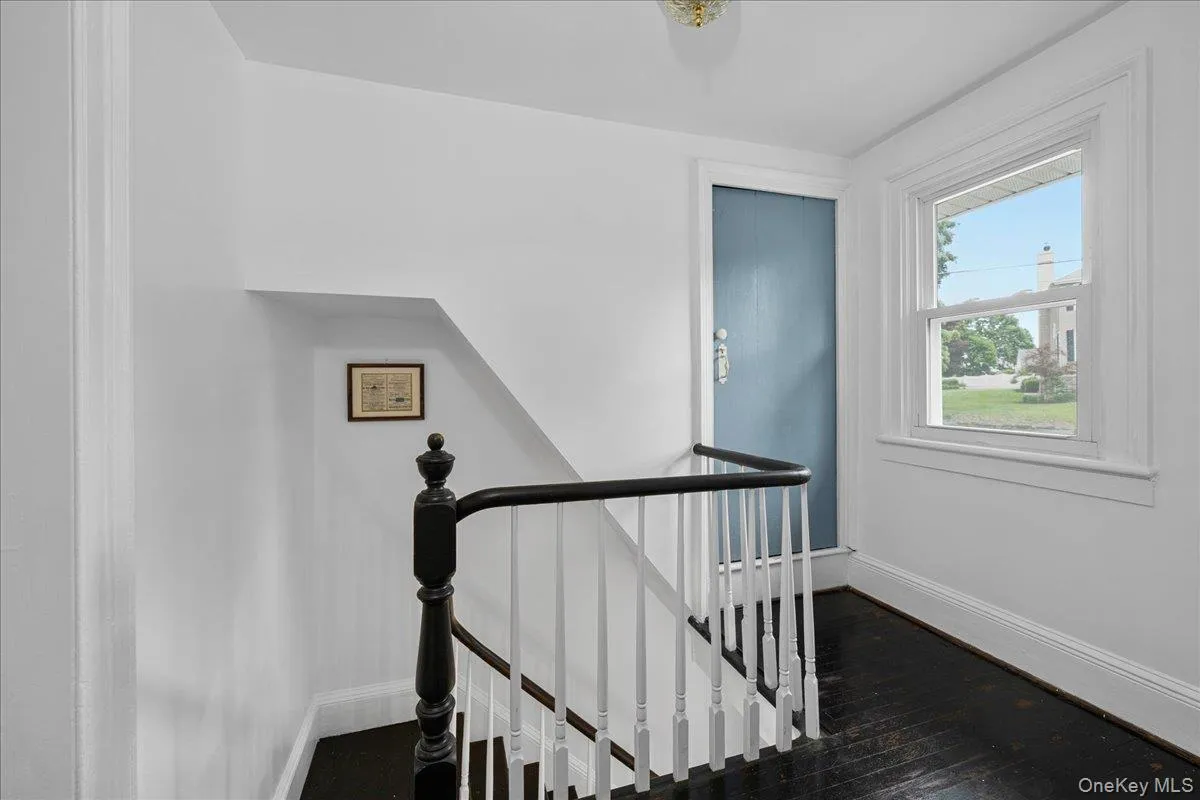 A bright and cheerful second floor hallway. The blue door leads to the attic stairs. A bright and cheerful second floor hallway. The blue door leads to the attic stairs.