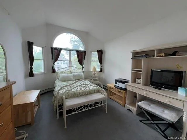 Vaulted ceiling room featuring multiple windows, including a prominent arched window Vaulted ceiling room featuring multiple windows, including a prominent arched window