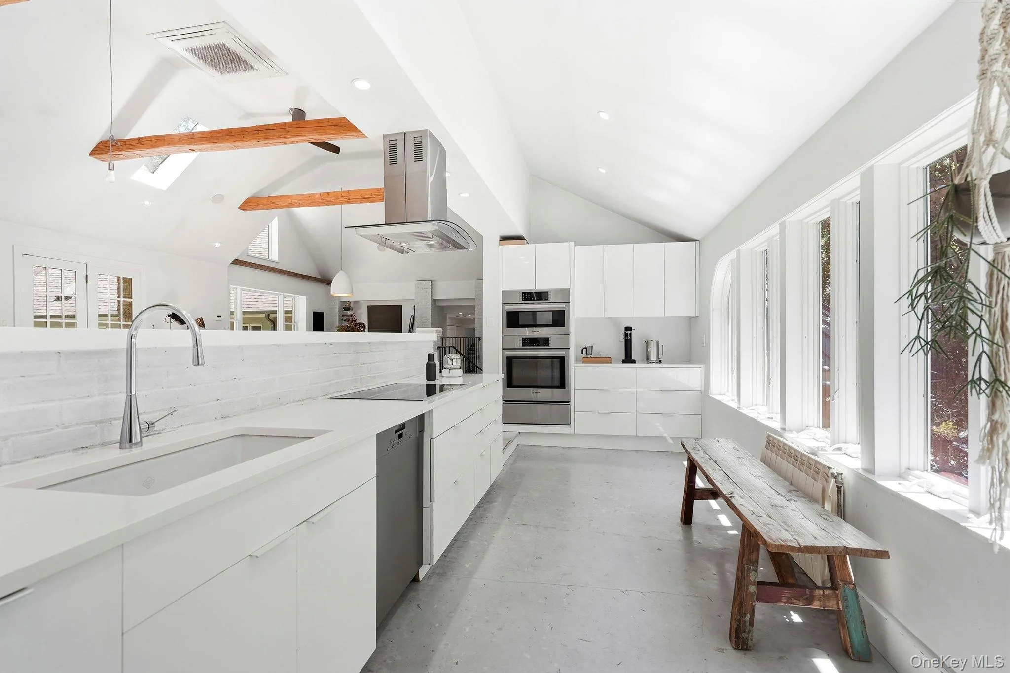 Custom-designed cabinetry and open shelving. Recycled quartz peninsula and countertops Custom-designed cabinetry and open shelving. Recycled quartz peninsula and countertops