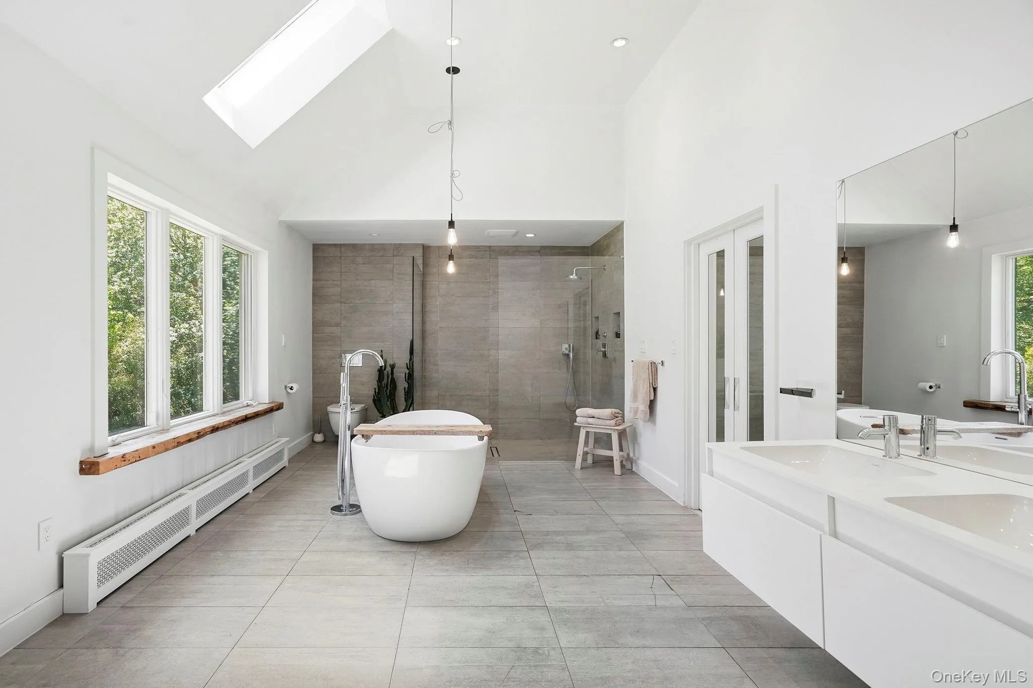 Primary ensuite with soaking tub, with a view of the garden Primary ensuite with soaking tub, with a view of the garden