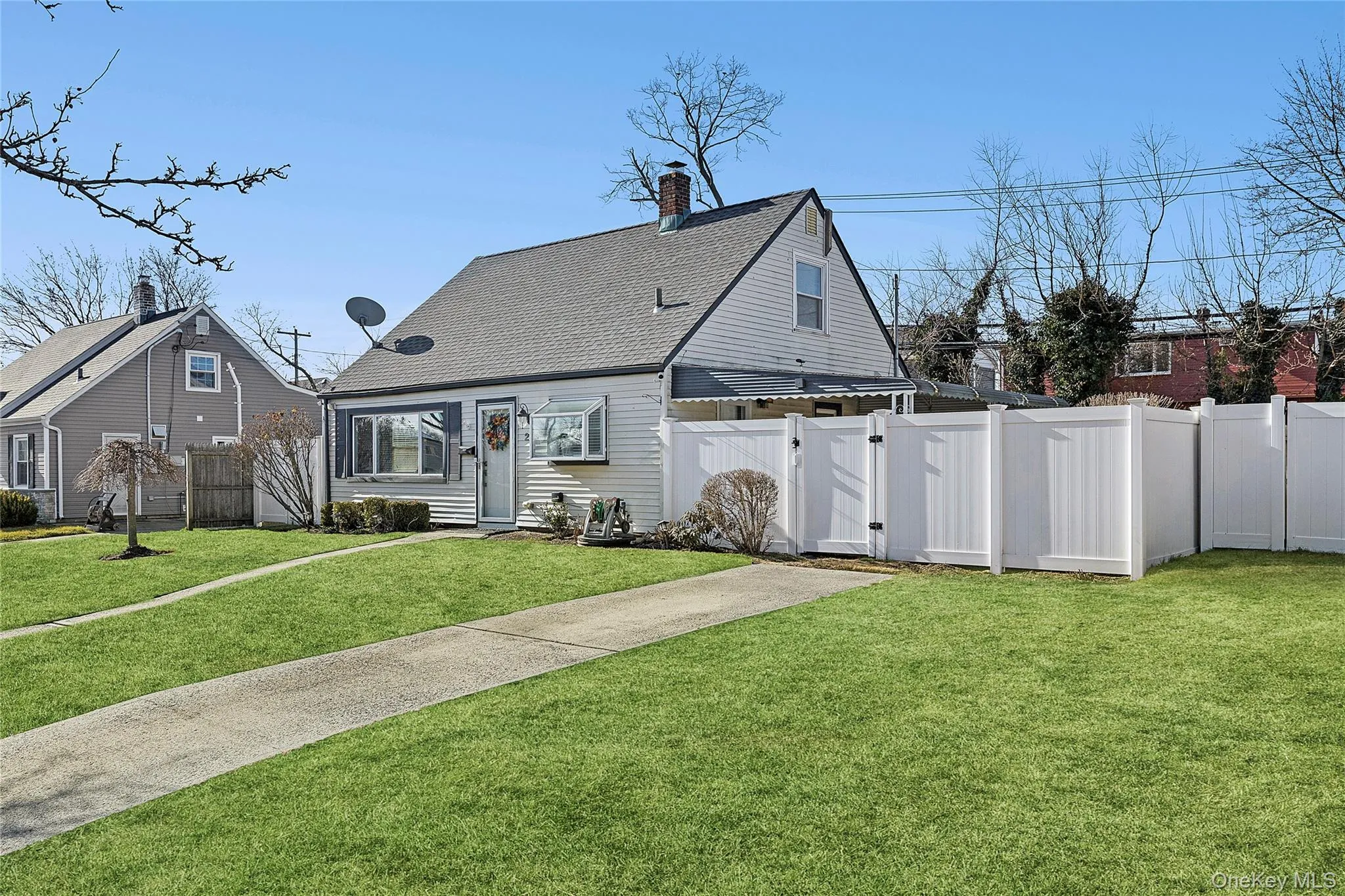 Gable-roof property featuring white siding and a front bay window Gable-roof property featuring white siding and a front bay window