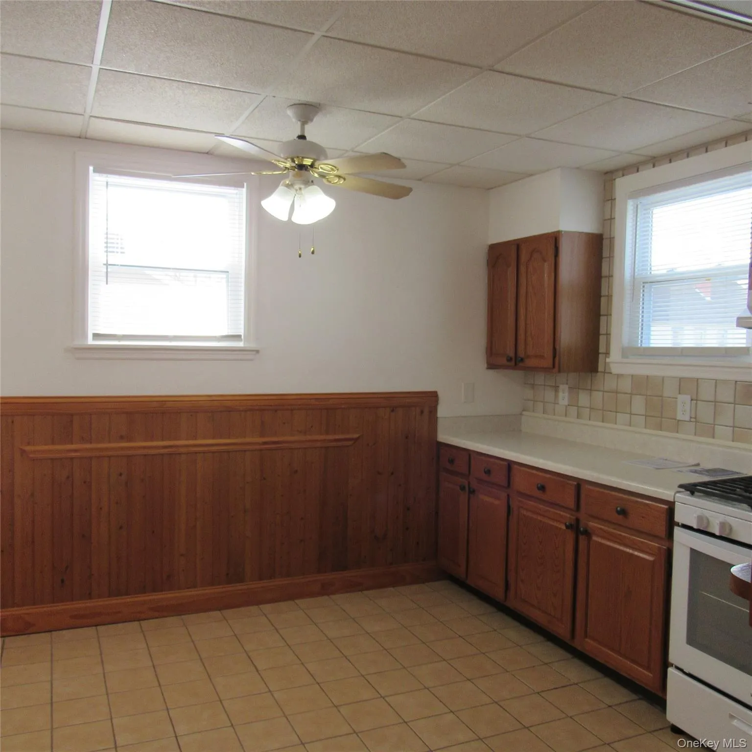 Eat-in-kitchen featuring healthy amount of natural light, brown cabinets, light countertops, new gas range, dishwasher and refridgerator Eat-in-kitchen featuring healthy amount of natural light, brown cabinets, light countertops, new gas range, dishwasher and refridgerator