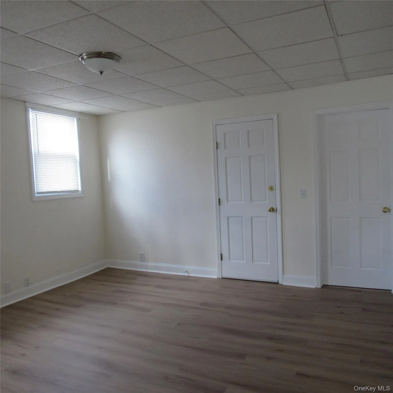 Livingroom featuring a paneled ceiling and wood finished floors Livingroom featuring a paneled ceiling and wood finished floors