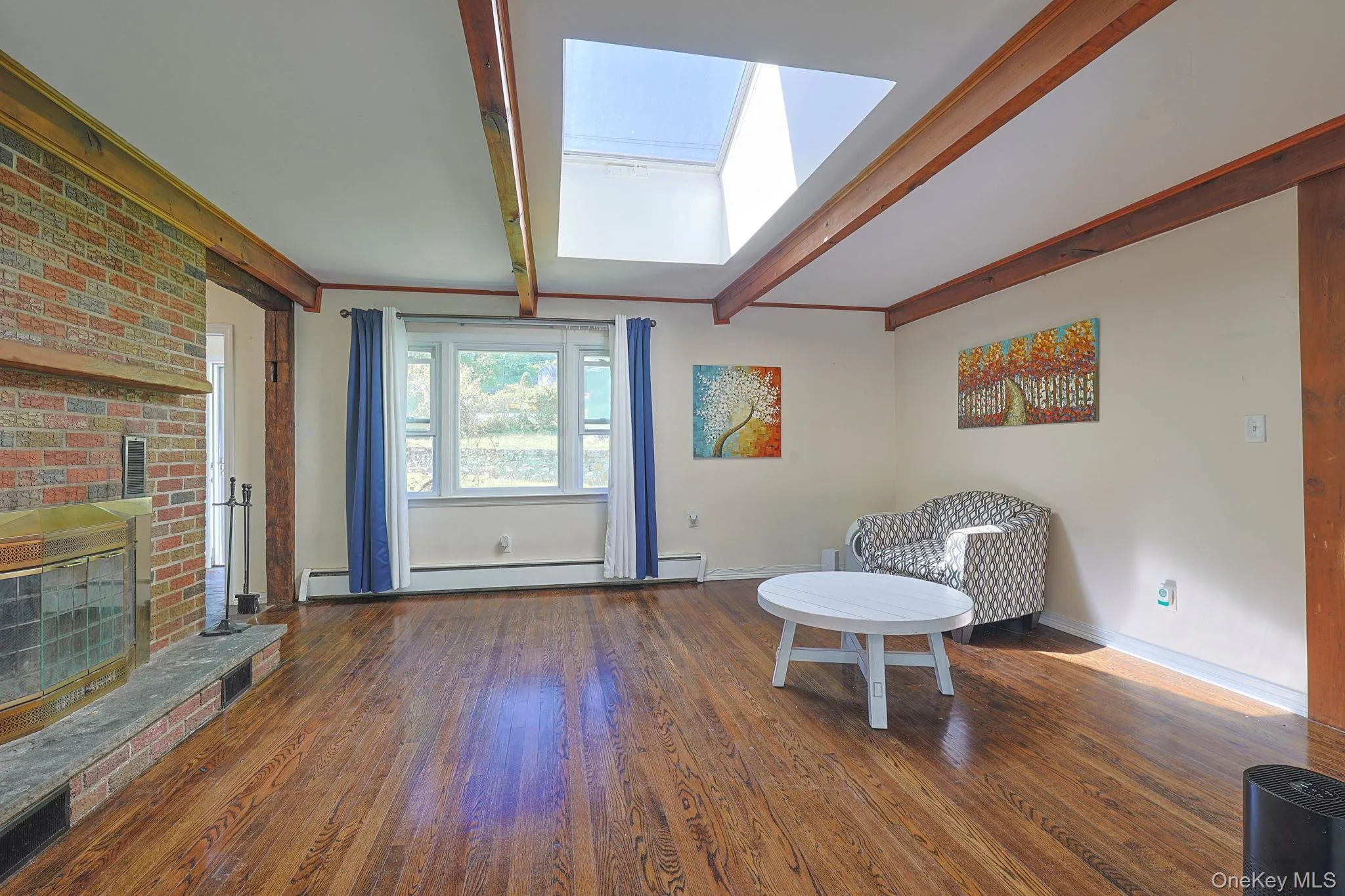 Bright and open Living Room with oversized skylight, Beamed ceilings and fireplace Bright and open Living Room with oversized skylight, Beamed ceilings and fireplace