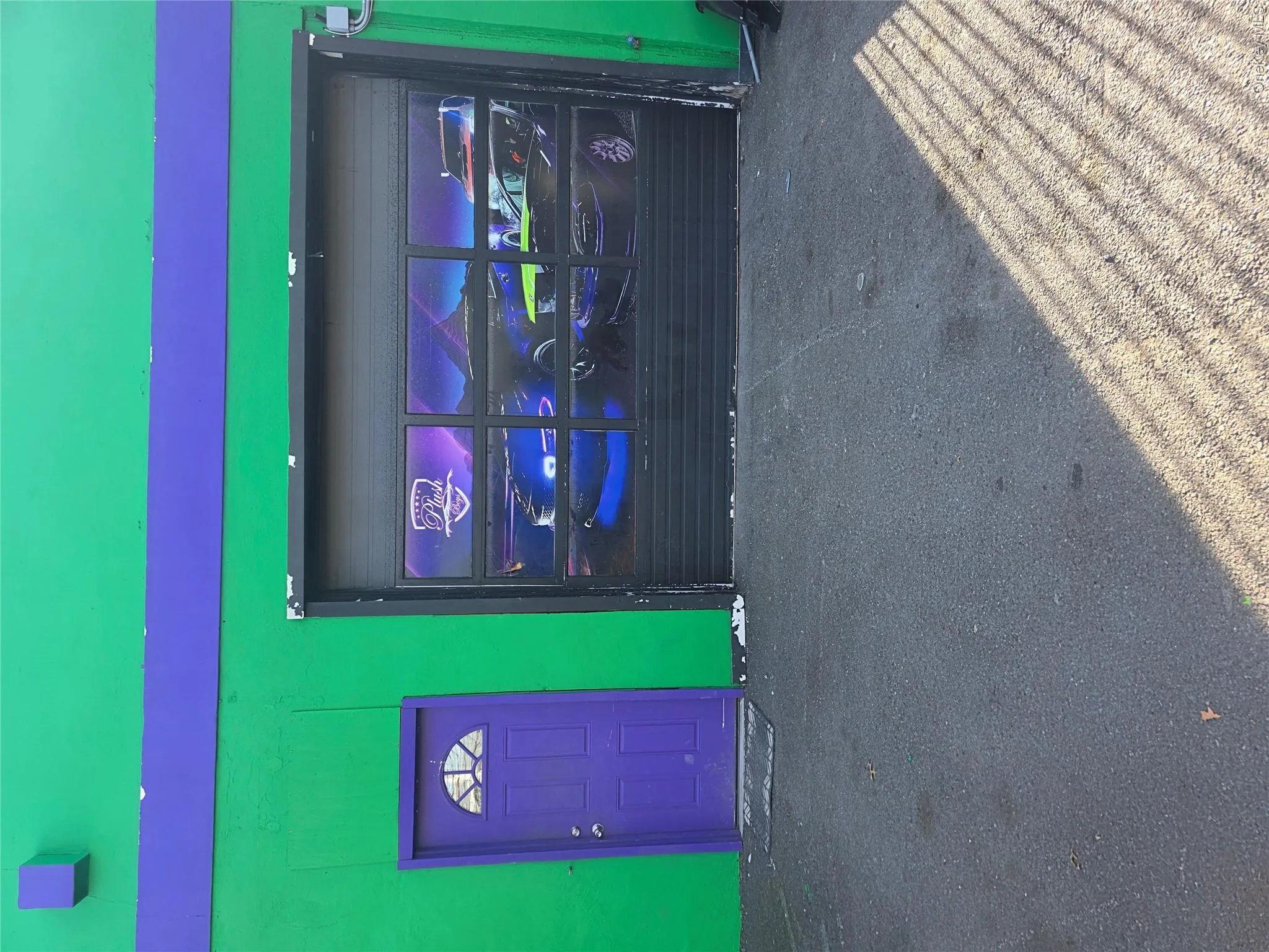 Commercial building exterior featuring a vibrant green facade with a purple accent band Commercial building exterior featuring a vibrant green facade with a purple accent band