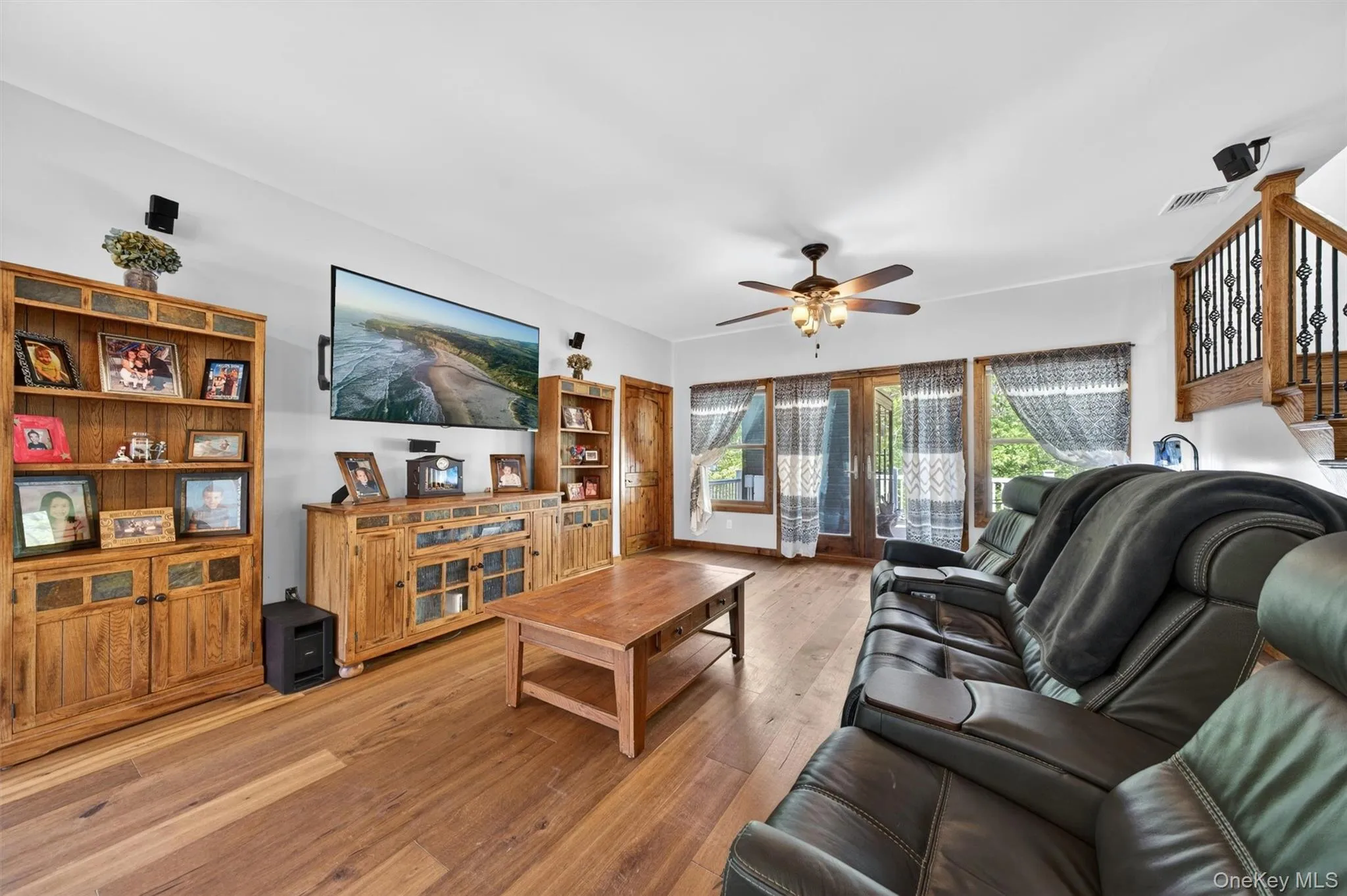 The spacious living room is a hub of relaxation, flanked by outdoor living spaces on both sides. Pictured here are the glass doors leading directly to the private rear deck. The spacious living room is a hub of relaxation, flanked by outdoor living spaces on both sides. Pictured here are the glass doors leading directly to the private rear deck.