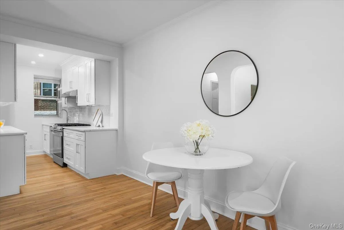 Bright dining area with hardwood floors, a round table setting, and easy access to the kitchen. Bright dining area with hardwood floors, a round table setting, and easy access to the kitchen.