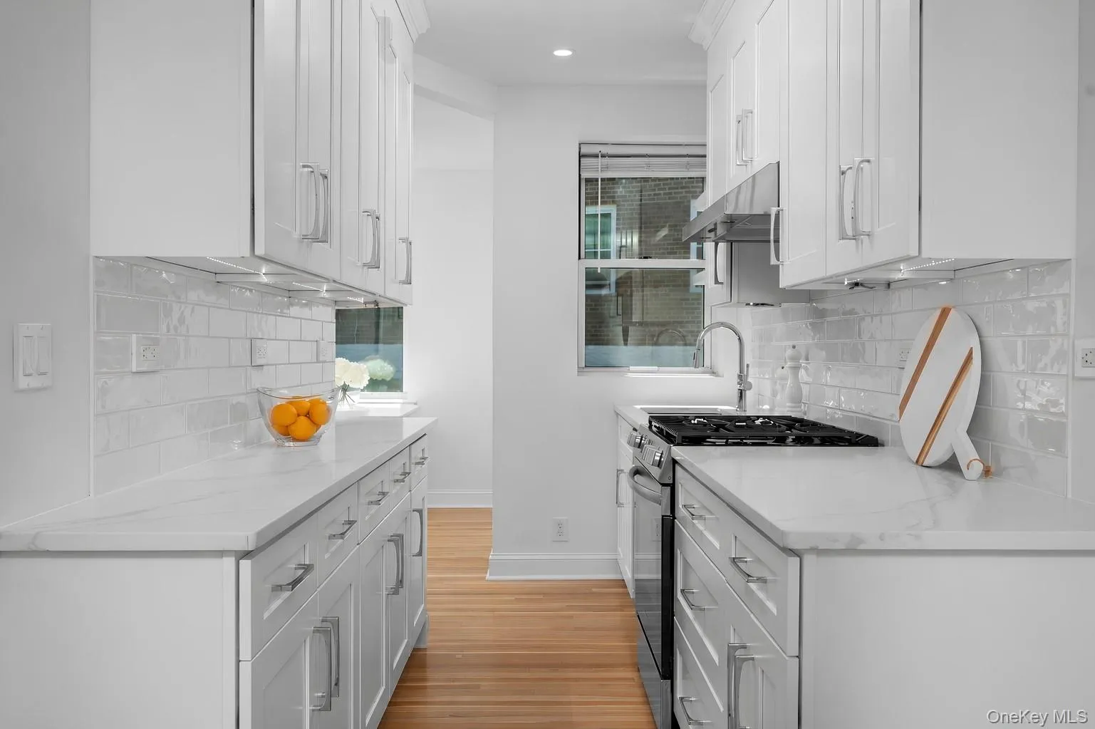 NEW luxe kitchen features white cabinetry, glossy subway tile backsplash, stainless steel appliances, and quartz countertops NEW luxe kitchen features white cabinetry, glossy subway tile backsplash, stainless steel appliances, and quartz countertops