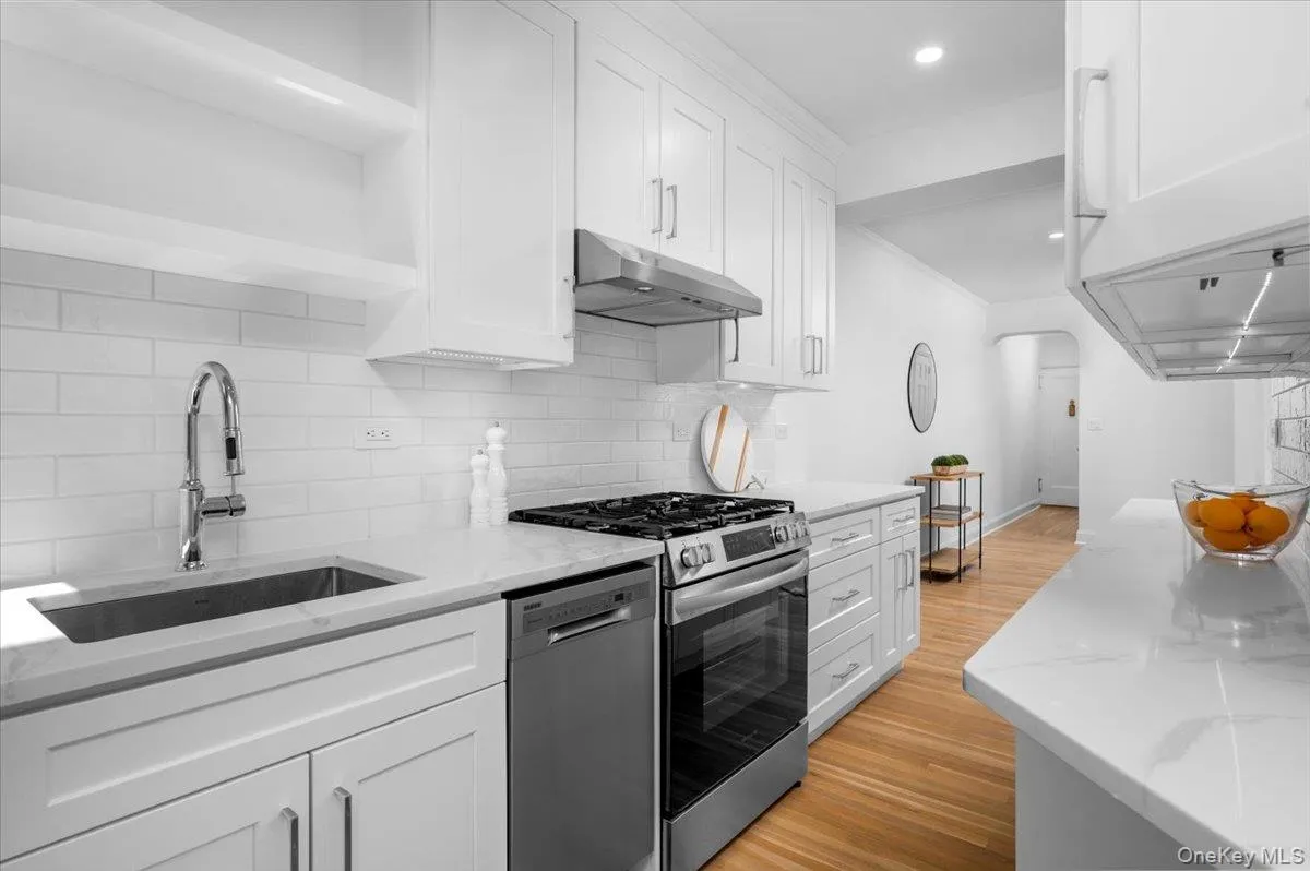 NEW kitchen features modern open shelving, white cabinetry, quartz countertops, stainless steel appliances, subway tile backsplash, and hardwood flooring. NEW kitchen features modern open shelving, white cabinetry, quartz countertops, stainless steel appliances, subway tile backsplash, and hardwood flooring.