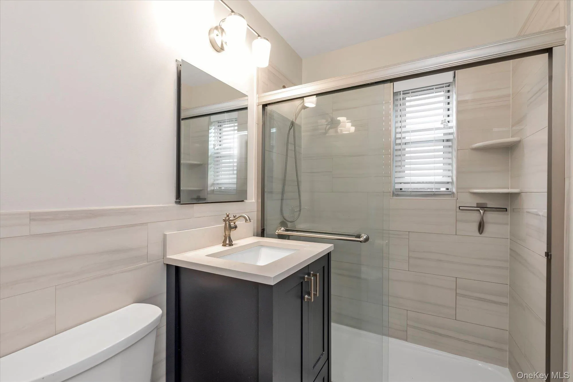 Contemporary bathroom featuring a dark wood-finish vanity with an integrated basin and a light-toned countertop Contemporary bathroom featuring a dark wood-finish vanity with an integrated basin and a light-toned countertop