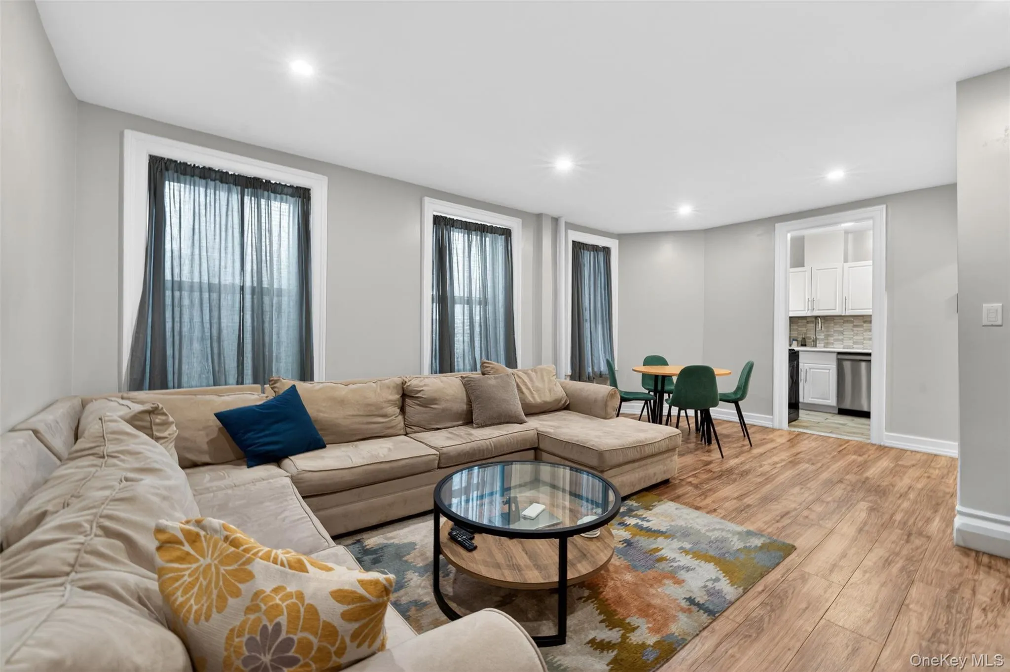 Open-concept living space featuring wood-finish flooring, recessed lighting, and multiple windows Open-concept living space featuring wood-finish flooring, recessed lighting, and multiple windows