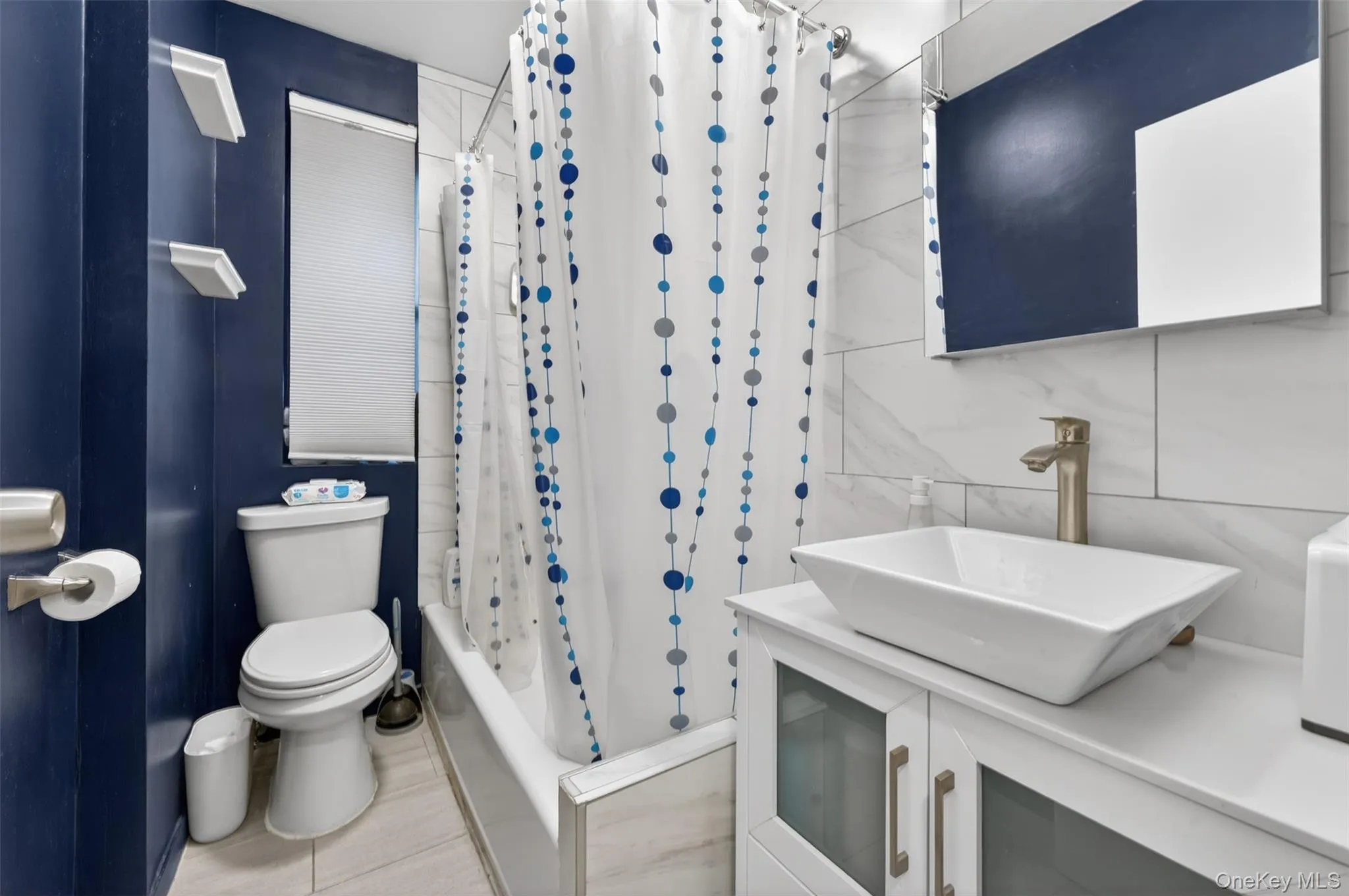 Bathroom featuring a white ceramic vessel sink with a brushed nickel faucet, set upon a white vanity with frosted glass cabinet doors Bathroom featuring a white ceramic vessel sink with a brushed nickel faucet, set upon a white vanity with frosted glass cabinet doors