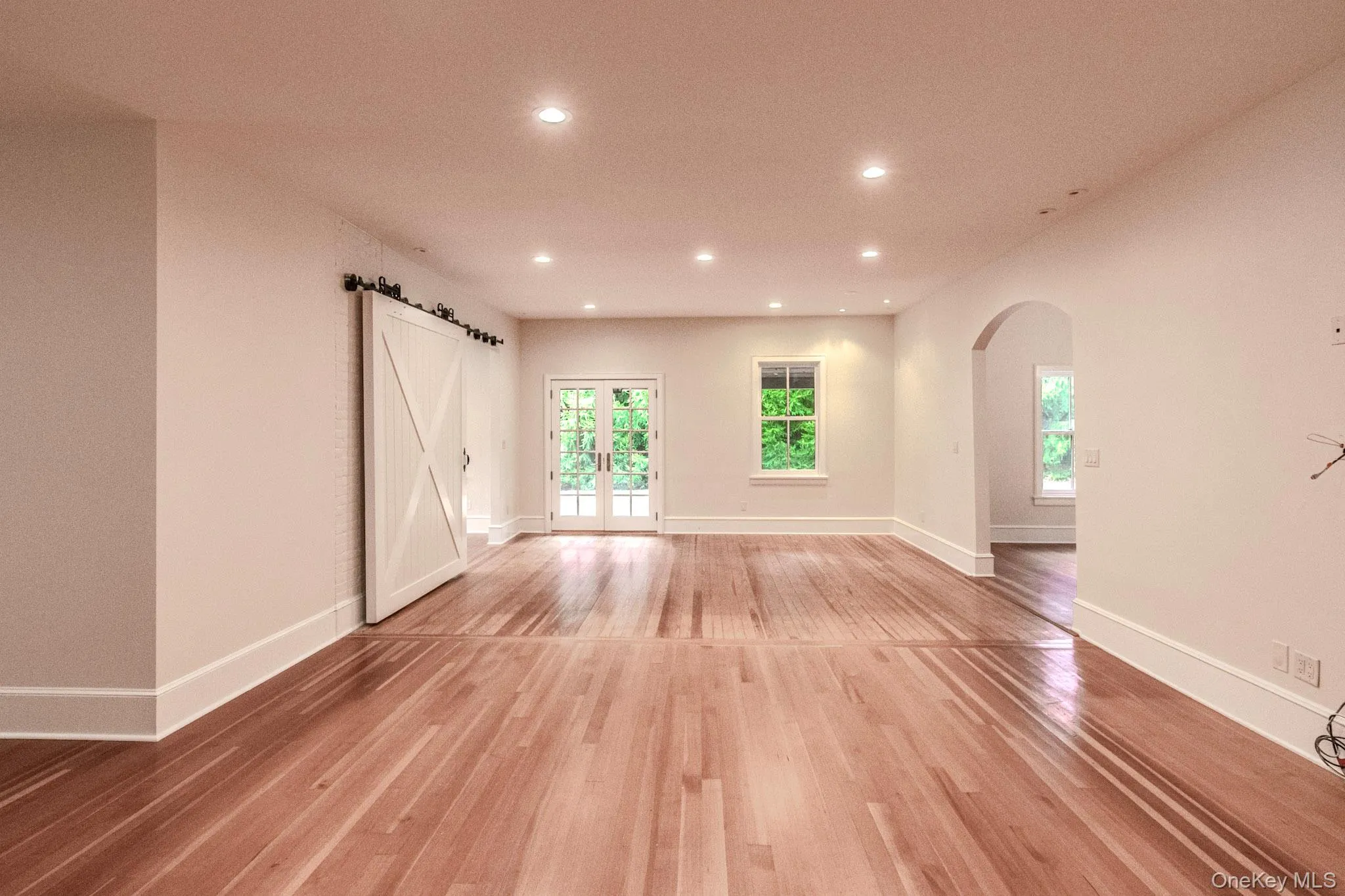 Spare room with plenty of natural light, french doors, and light wood-type flooring Spare room with plenty of natural light, french doors, and light wood-type flooring