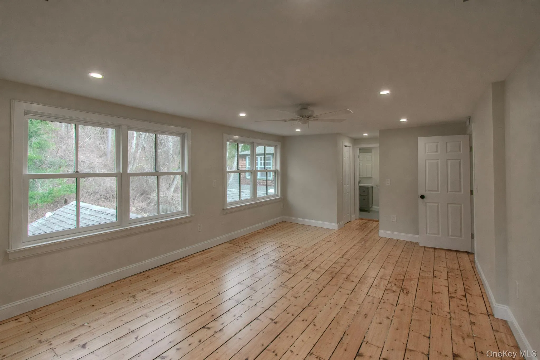 Unfurnished living room featuring ceiling fan, a wealth of natural light, and light hardwood / wood-style flooring Unfurnished living room featuring ceiling fan, a wealth of natural light, and light hardwood / wood-style flooring