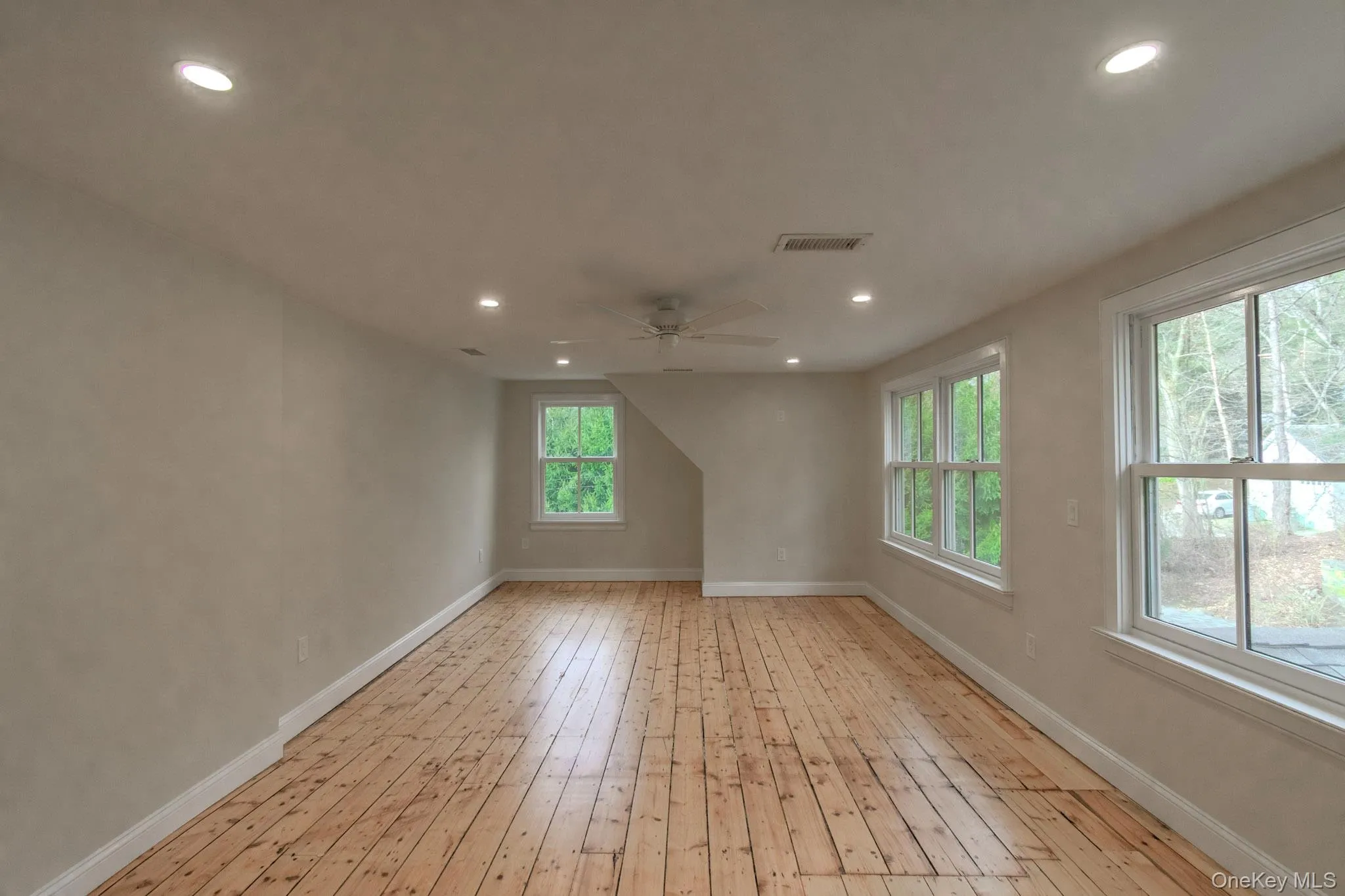 Empty room with light wood-type flooring and ceiling fan Empty room with light wood-type flooring and ceiling fan