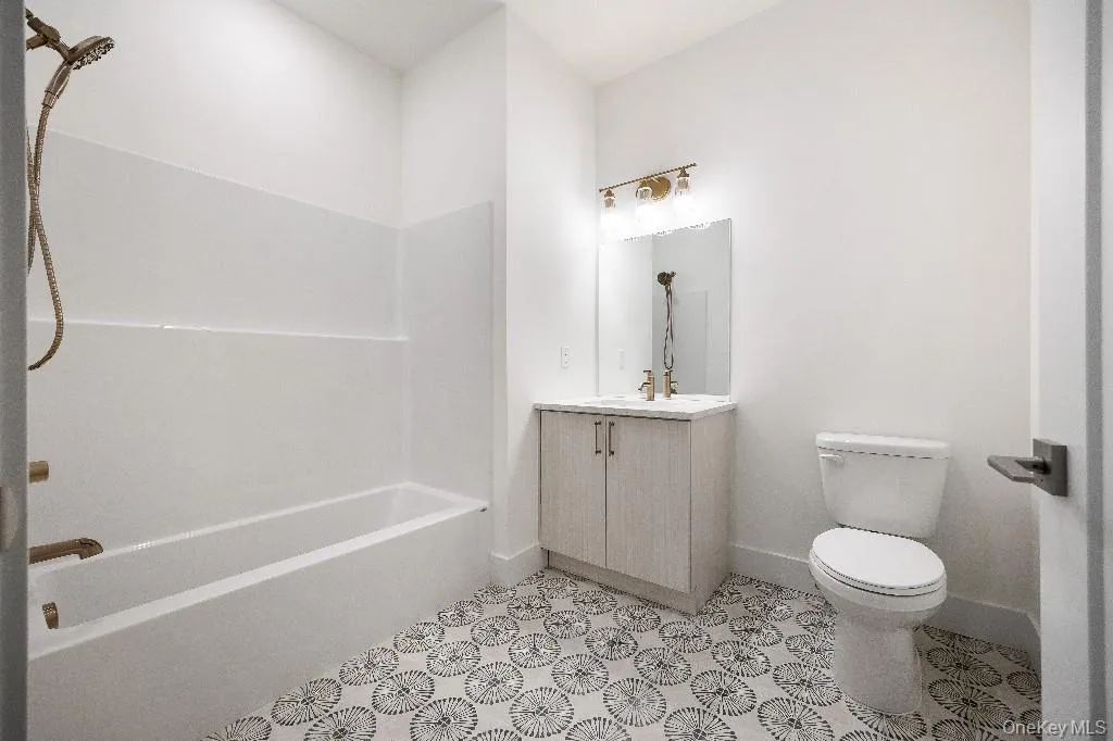 Full bathroom featuring shower / bathing tub combination, vanity, and toilet Full bathroom featuring shower / bathing tub combination, vanity, and toilet