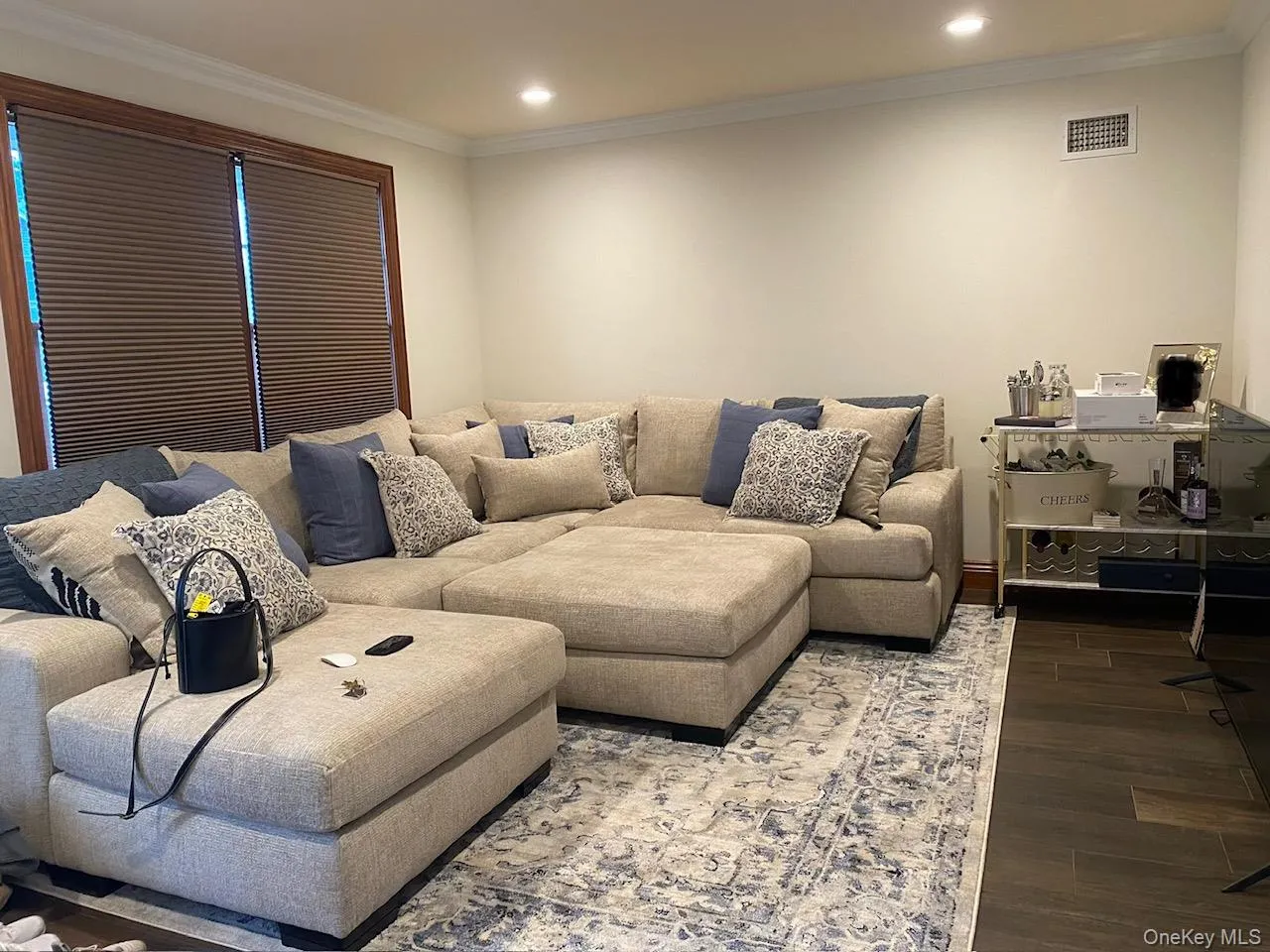Recessed lighting illuminates this room featuring crown molding, neutral wall tones, and wood-trim windows Recessed lighting illuminates this room featuring crown molding, neutral wall tones, and wood-trim windows