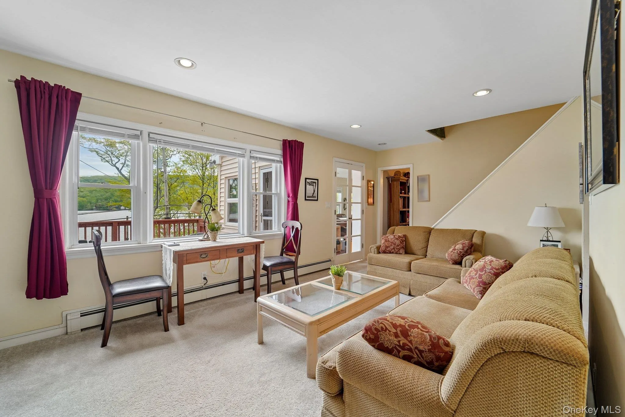 Living room showing entry way to enclosed front porch, stairs up and entrance to music room. Living room showing entry way to enclosed front porch, stairs up and entrance to music room.