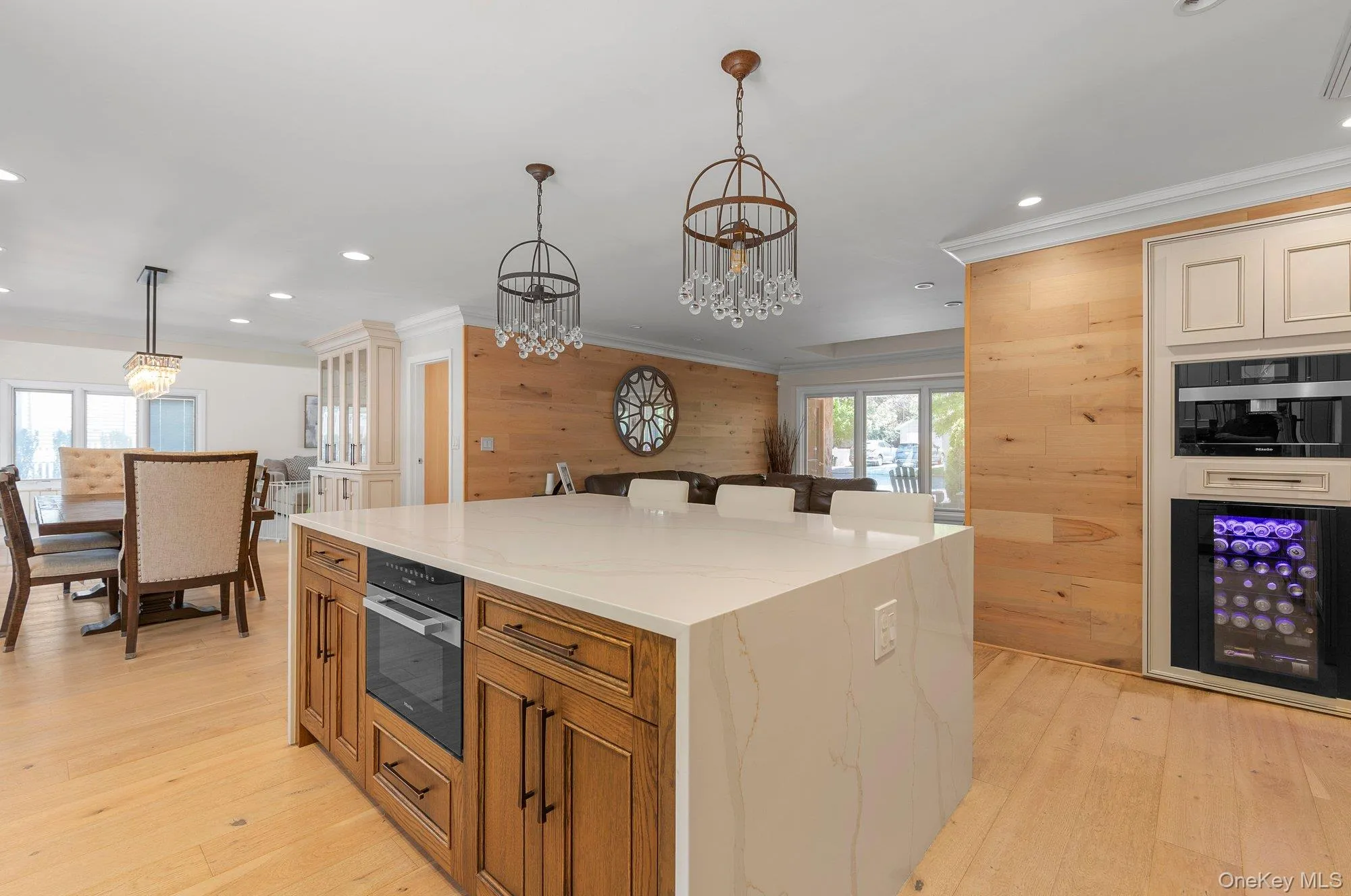 Kitchen island with a waterfall countertop, integrated oven, and wood-finish cabinetry Kitchen island with a waterfall countertop, integrated oven, and wood-finish cabinetry