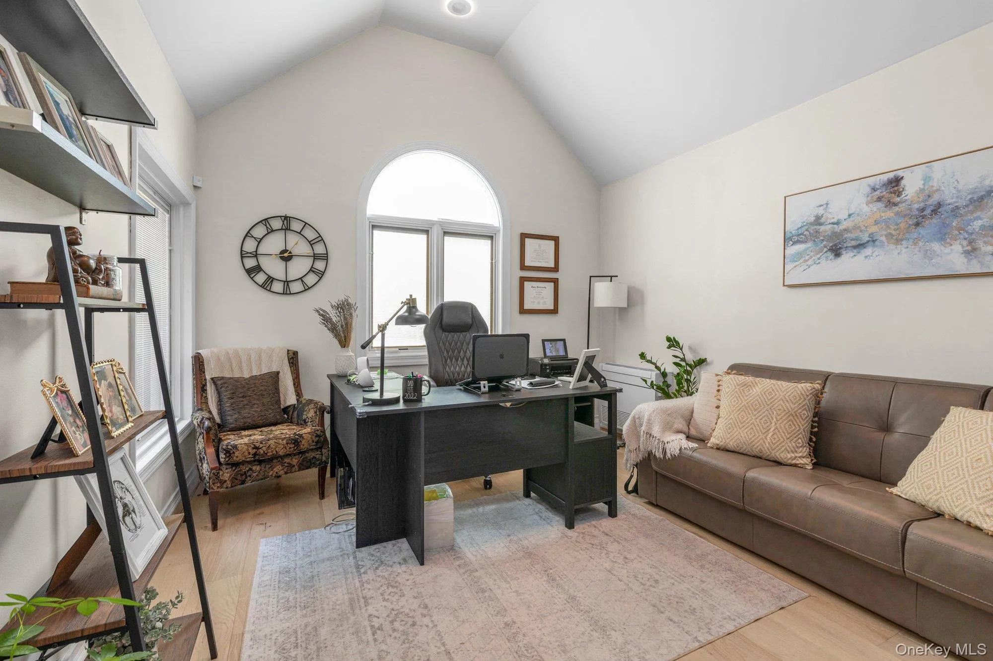 Vaulted ceiling room featuring light-toned wood-finish flooring Vaulted ceiling room featuring light-toned wood-finish flooring