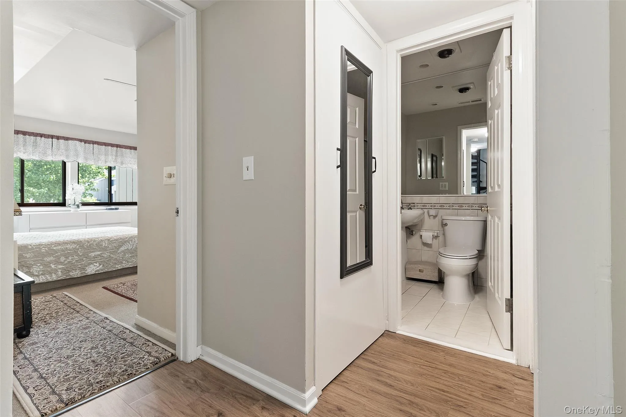 Hallway featuring wood-finish flooring and laundry Hallway featuring wood-finish flooring and laundry