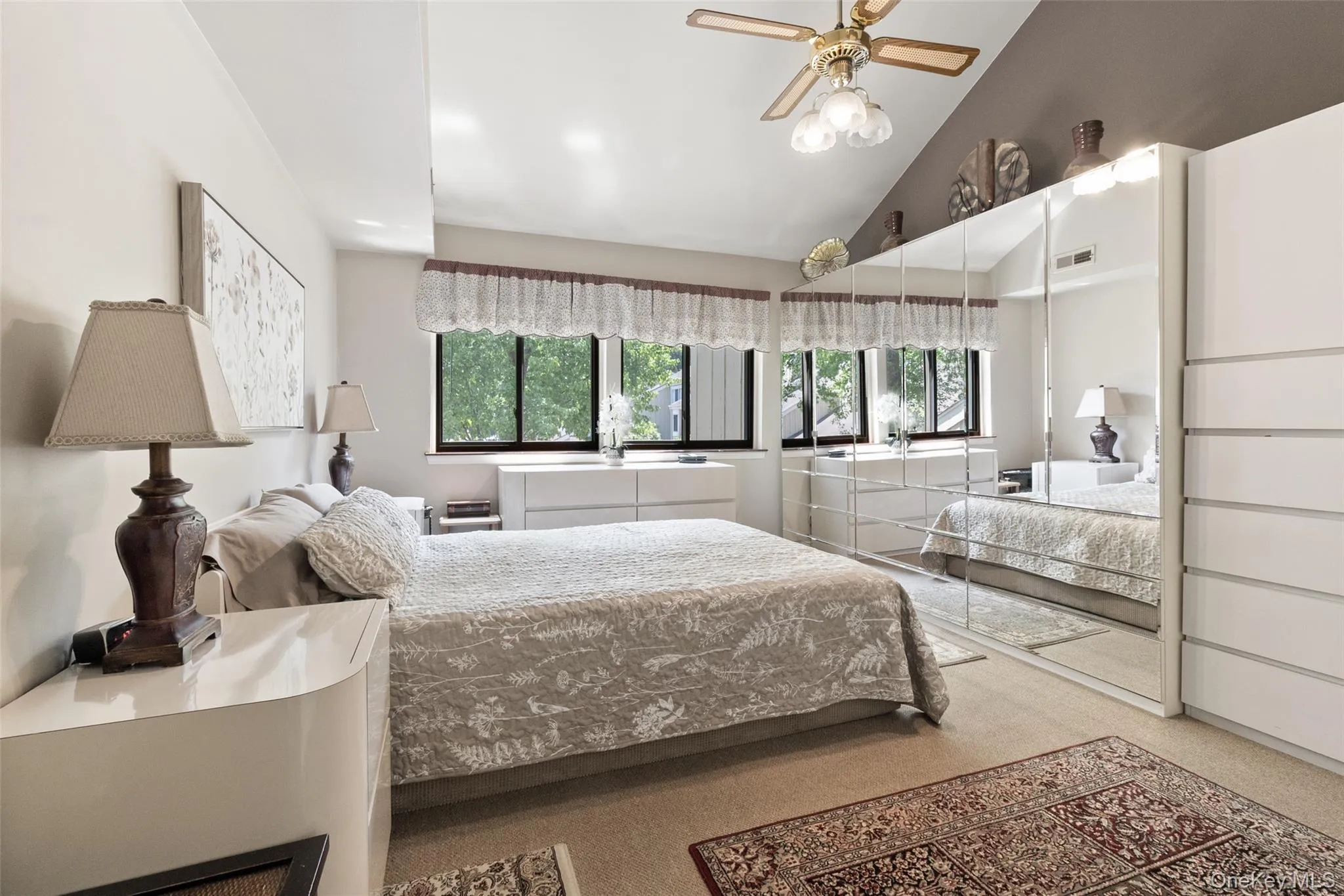 Primary bedroom with vaulted ceiling. Showcasing an abundance of windows that keep the space naturally light and open. Primary bedroom with vaulted ceiling. Showcasing an abundance of windows that keep the space naturally light and open.